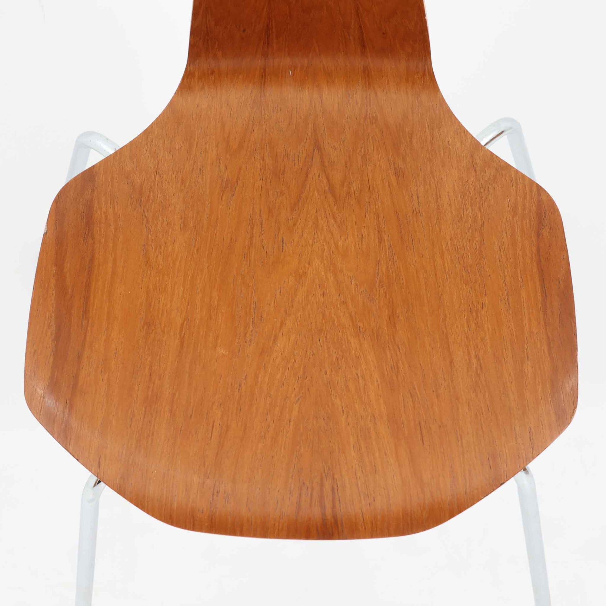 アルネ・ヤコブセンがデザインし、Fritz Hansenが製造した「T Chair」です。チーク材の成形合板による背座一体型のシェルは、背面上部を左右に広げた特徴的なシルエットと、身体に沿う緩やかな曲面が魅力。細身の金属脚との組み合わせが軽快で、ダイニングはもちろん、書斎や玄関のアクセントチェアにもおすすめです。美しい木目と時を重ねた風合い、合理的な構造に宿る北欧ビンテージらしい存在感を楽しめます。