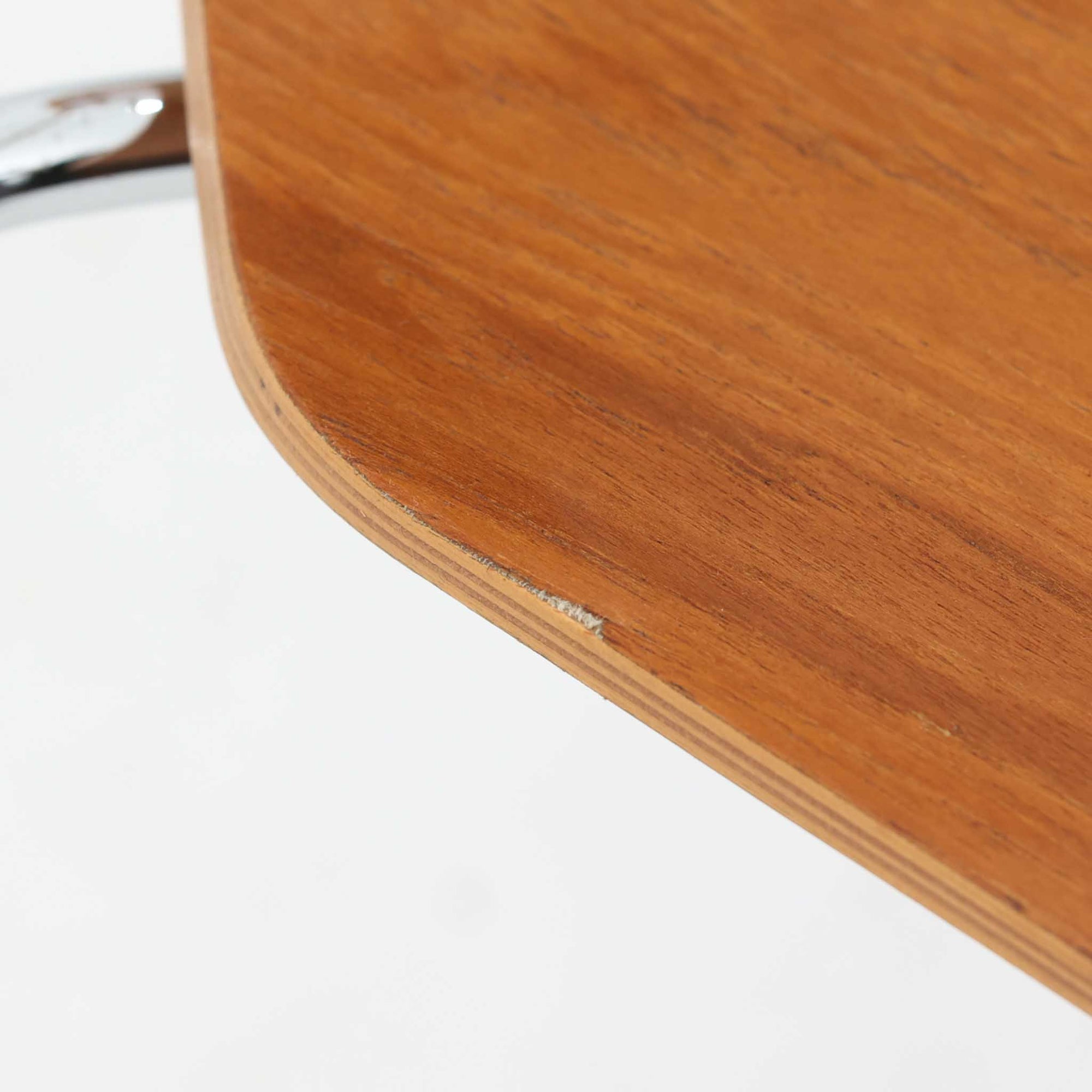 アルネ・ヤコブセンがデザインし、Fritz Hansenが製造した「T Chair」です。チーク材の成形合板による背座一体型のシェルは、背面上部を左右に広げた特徴的なシルエットと、身体に沿う緩やかな曲面が魅力。細身の金属脚との組み合わせが軽快で、ダイニングはもちろん、書斎や玄関のアクセントチェアにもおすすめです。美しい木目と時を重ねた風合い、合理的な構造に宿る北欧ビンテージらしい存在感を楽しめます。