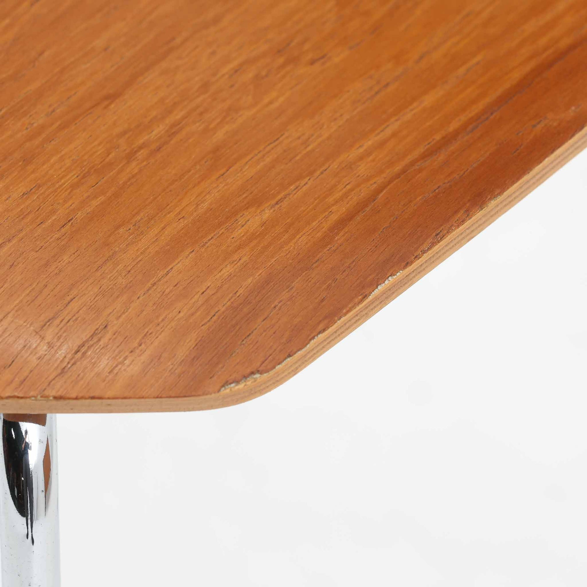 アルネ・ヤコブセンがデザインし、Fritz Hansenが製造した「T Chair」です。チーク材の成形合板による背座一体型のシェルは、背面上部を左右に広げた特徴的なシルエットと、身体に沿う緩やかな曲面が魅力。細身の金属脚との組み合わせが軽快で、ダイニングはもちろん、書斎や玄関のアクセントチェアにもおすすめです。美しい木目と時を重ねた風合い、合理的な構造に宿る北欧ビンテージらしい存在感を楽しめます。