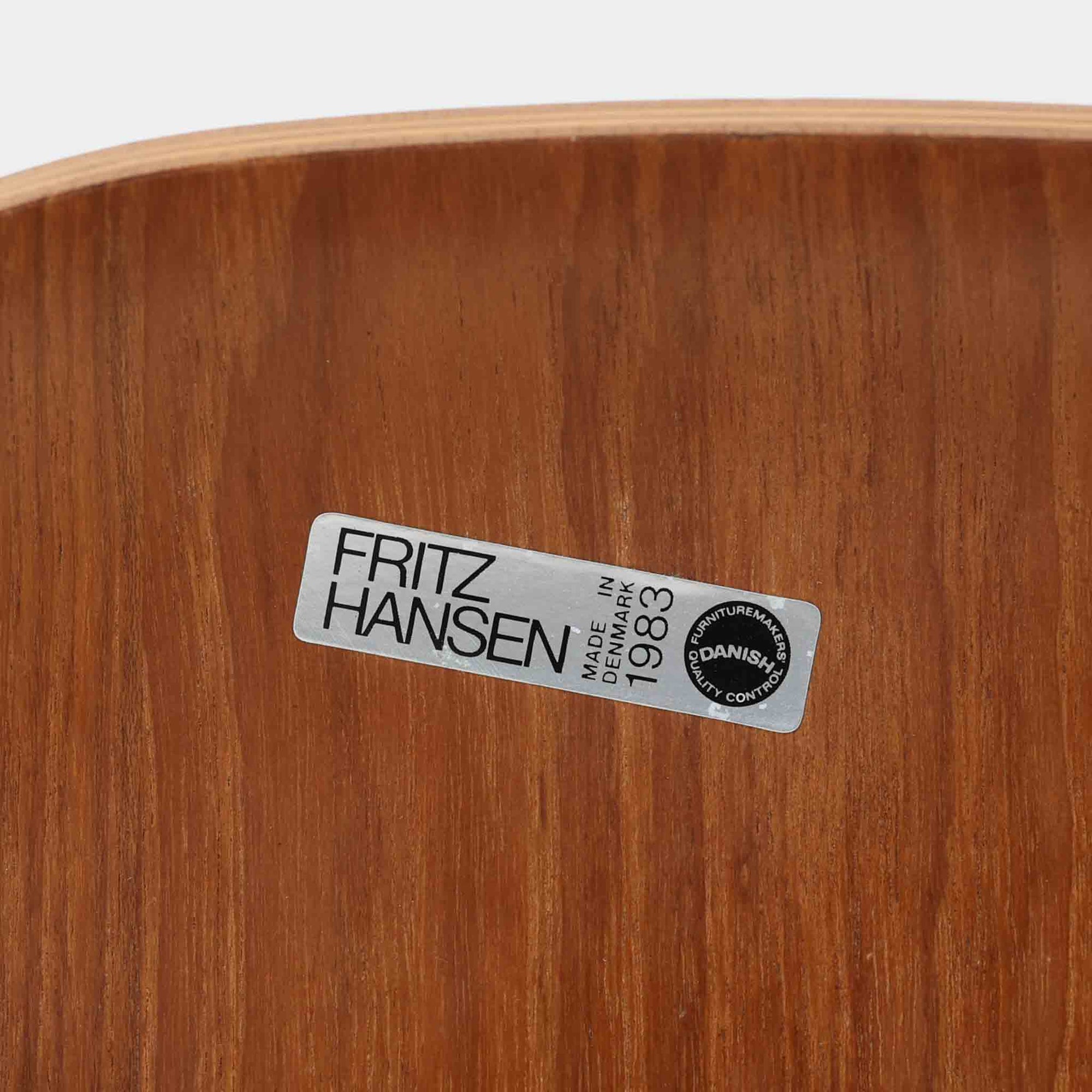 アルネ・ヤコブセンがデザインし、Fritz Hansenが製造した「T Chair」です。チーク材の成形合板による背座一体型のシェルは、背面上部を左右に広げた特徴的なシルエットと、身体に沿う緩やかな曲面が魅力。細身の金属脚との組み合わせが軽快で、ダイニングはもちろん、書斎や玄関のアクセントチェアにもおすすめです。美しい木目と時を重ねた風合い、合理的な構造に宿る北欧ビンテージらしい存在感を楽しめます。