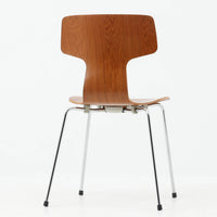 アルネ・ヤコブセンがデザインし、Fritz Hansenが製造した「T Chair」です。チーク材の成形合板による背座一体型のシェルは、背面上部を左右に広げた特徴的なシルエットと、身体に沿う緩やかな曲面が魅力。細身の金属脚との組み合わせが軽快で、ダイニングはもちろん、書斎や玄関のアクセントチェアにもおすすめです。美しい木目と時を重ねた風合い、合理的な構造に宿る北欧ビンテージらしい存在感を楽しめます。
