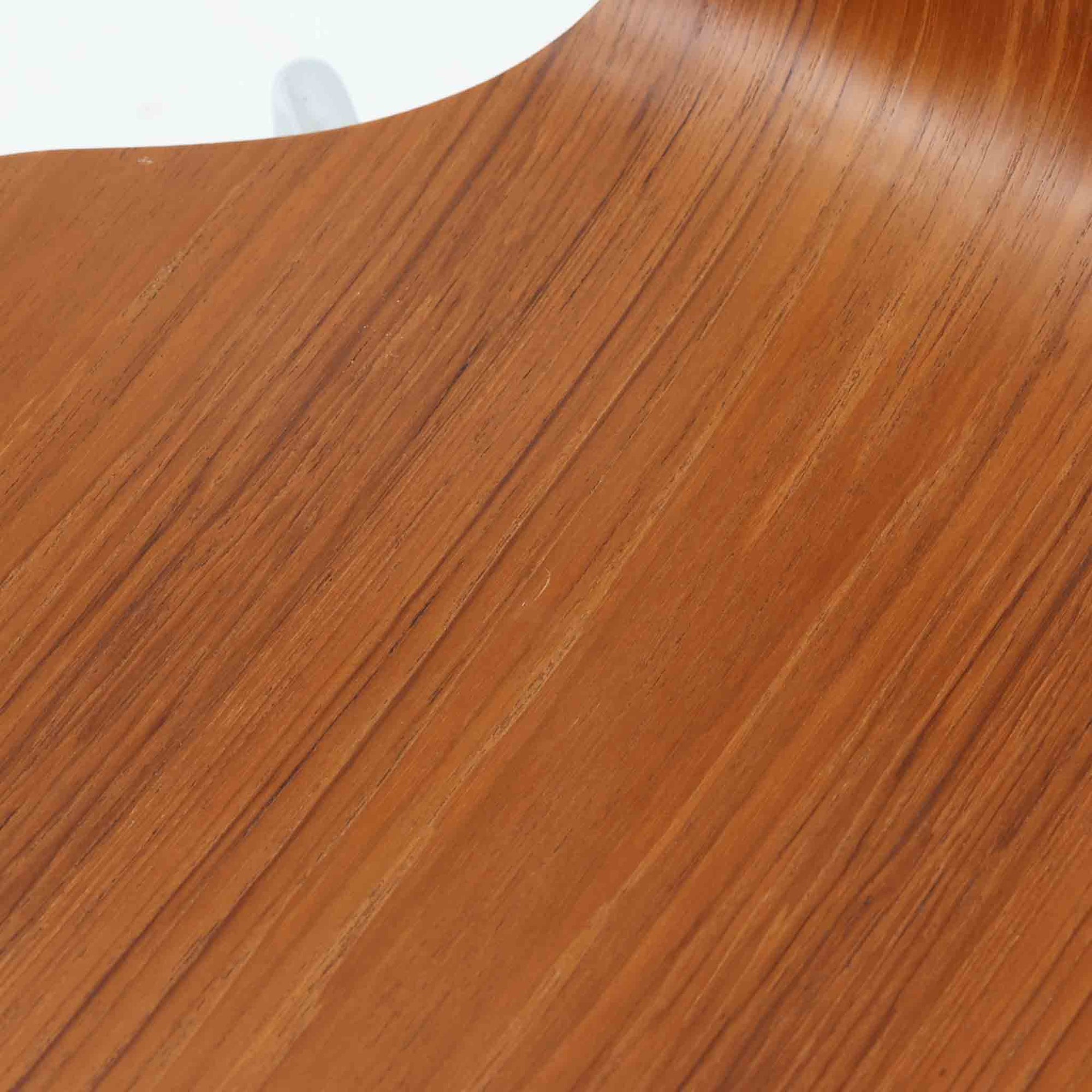 アルネ・ヤコブセンがデザインし、Fritz Hansenが製造した「T Chair」です。チーク材の成形合板による背座一体型のシェルは、背面上部を左右に広げた特徴的なシルエットと、身体に沿う緩やかな曲面が魅力。細身の金属脚との組み合わせが軽快で、ダイニングはもちろん、書斎や玄関のアクセントチェアにもおすすめです。美しい木目と時を重ねた風合い、合理的な構造に宿る北欧ビンテージらしい存在感を楽しめます。