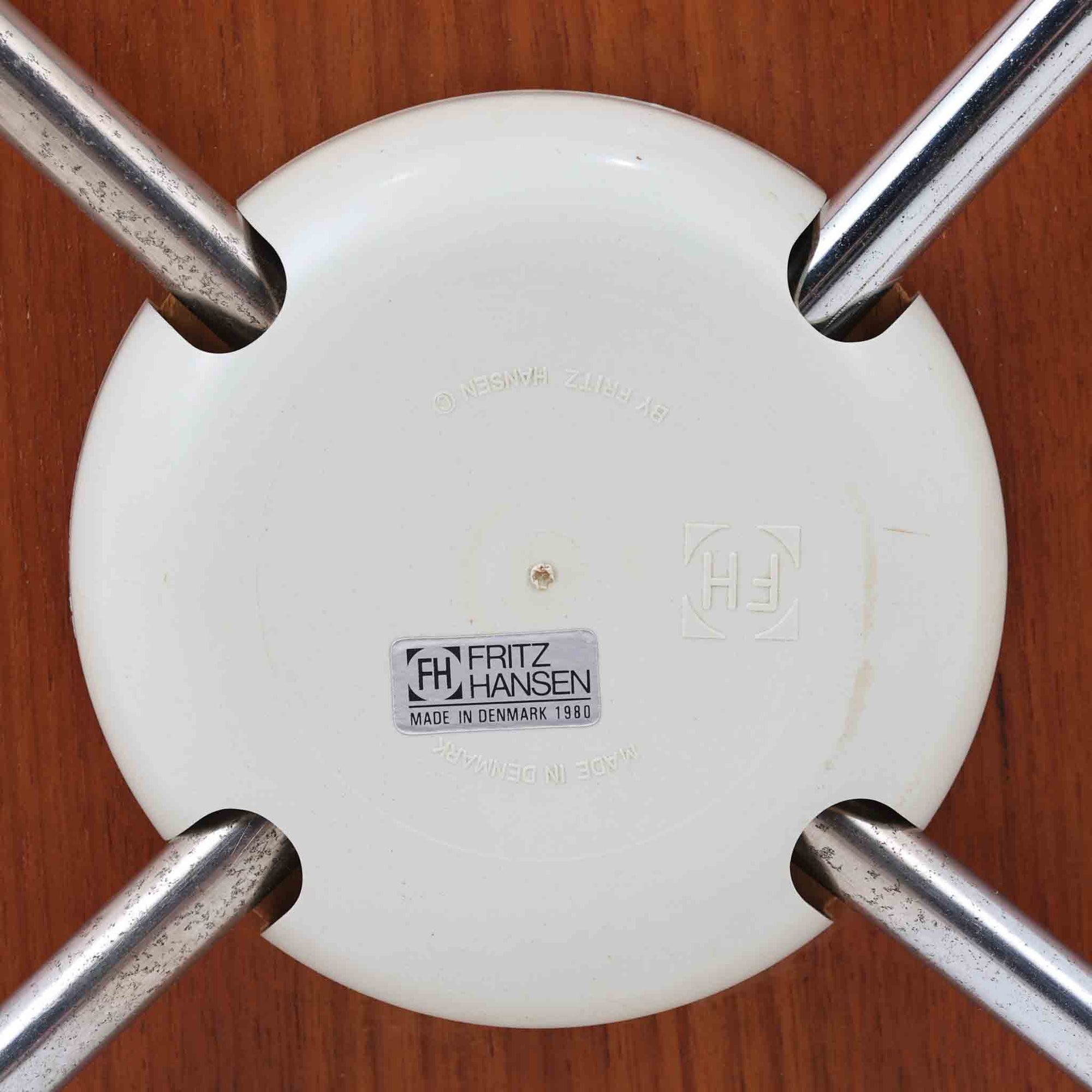 アルネ・ヤコブセンがデザインし、Fritz Hansenが製造した「T Chair」です。チーク材の成形合板による背座一体型のシェルは、背面上部を左右に広げた特徴的なシルエットと、身体に沿う緩やかな曲面が魅力。細身の金属脚との組み合わせが軽快で、ダイニングはもちろん、書斎や玄関のアクセントチェアにもおすすめです。美しい木目と時を重ねた風合い、合理的な構造に宿る北欧ビンテージらしい存在感を楽しめます。