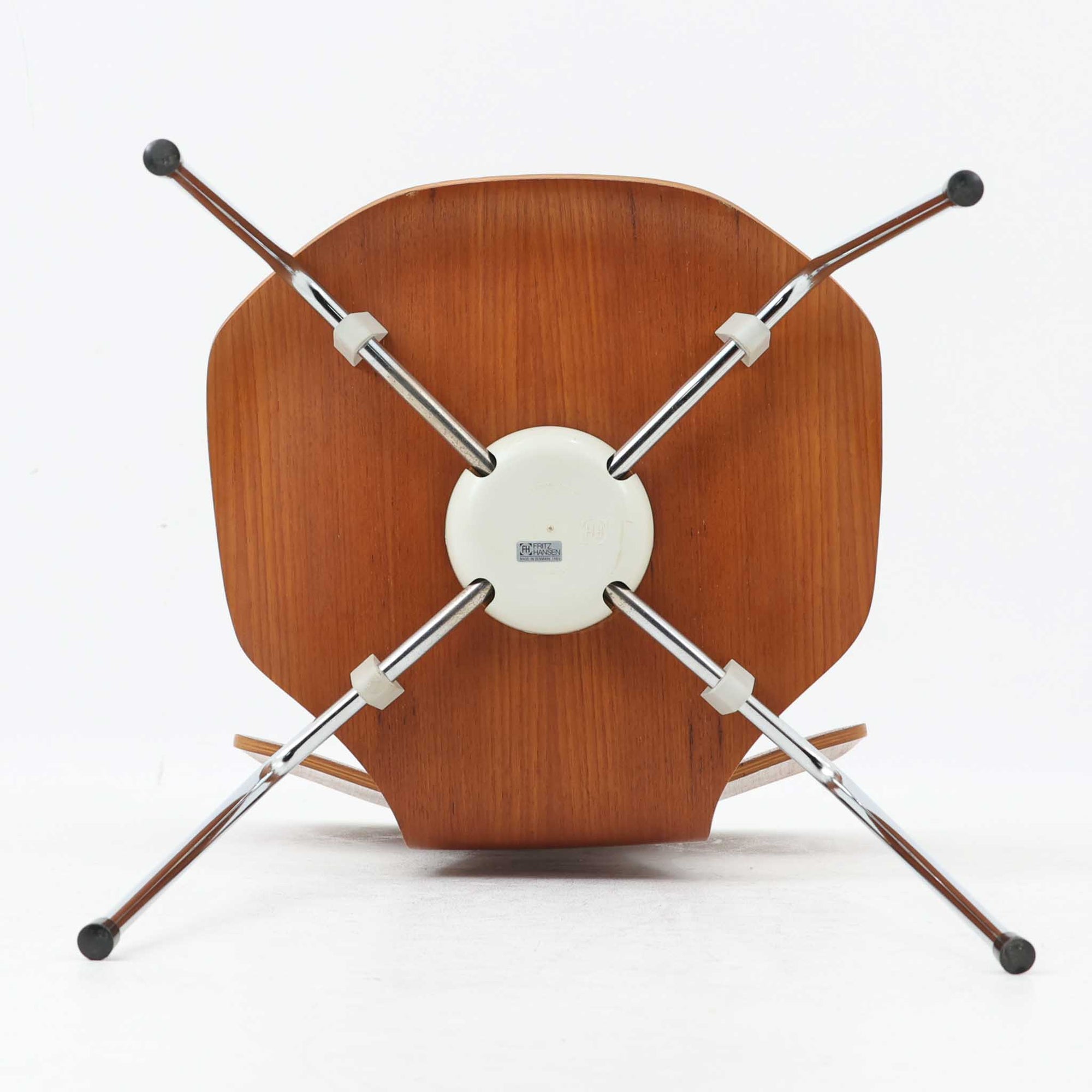 アルネ・ヤコブセンがデザインし、Fritz Hansenが製造した「T Chair」です。チーク材の成形合板による背座一体型のシェルは、背面上部を左右に広げた特徴的なシルエットと、身体に沿う緩やかな曲面が魅力。細身の金属脚との組み合わせが軽快で、ダイニングはもちろん、書斎や玄関のアクセントチェアにもおすすめです。美しい木目と時を重ねた風合い、合理的な構造に宿る北欧ビンテージらしい存在感を楽しめます。