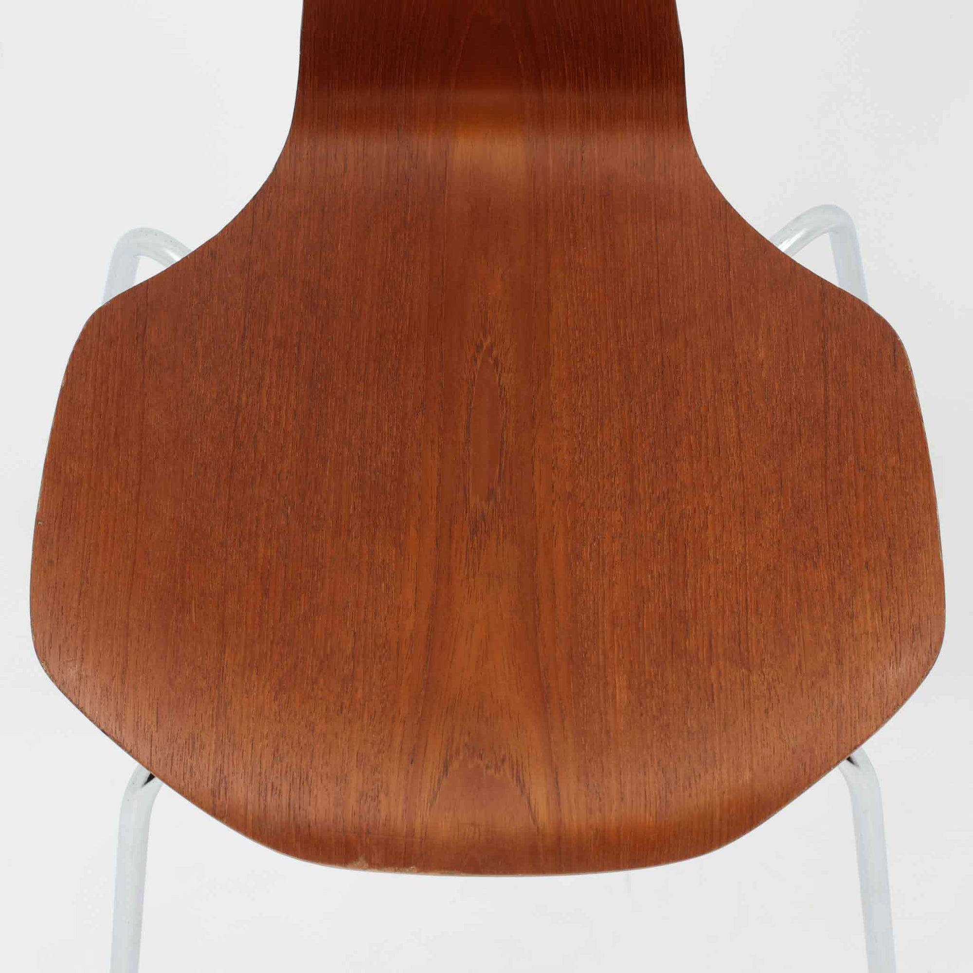 アルネ・ヤコブセンがデザインし、Fritz Hansenが製造した「T Chair」です。チーク材の成形合板による背座一体型のシェルは、背面上部を左右に広げた特徴的なシルエットと、身体に沿う緩やかな曲面が魅力。細身の金属脚との組み合わせが軽快で、ダイニングはもちろん、書斎や玄関のアクセントチェアにもおすすめです。美しい木目と時を重ねた風合い、合理的な構造に宿る北欧ビンテージらしい存在感を楽しめます。