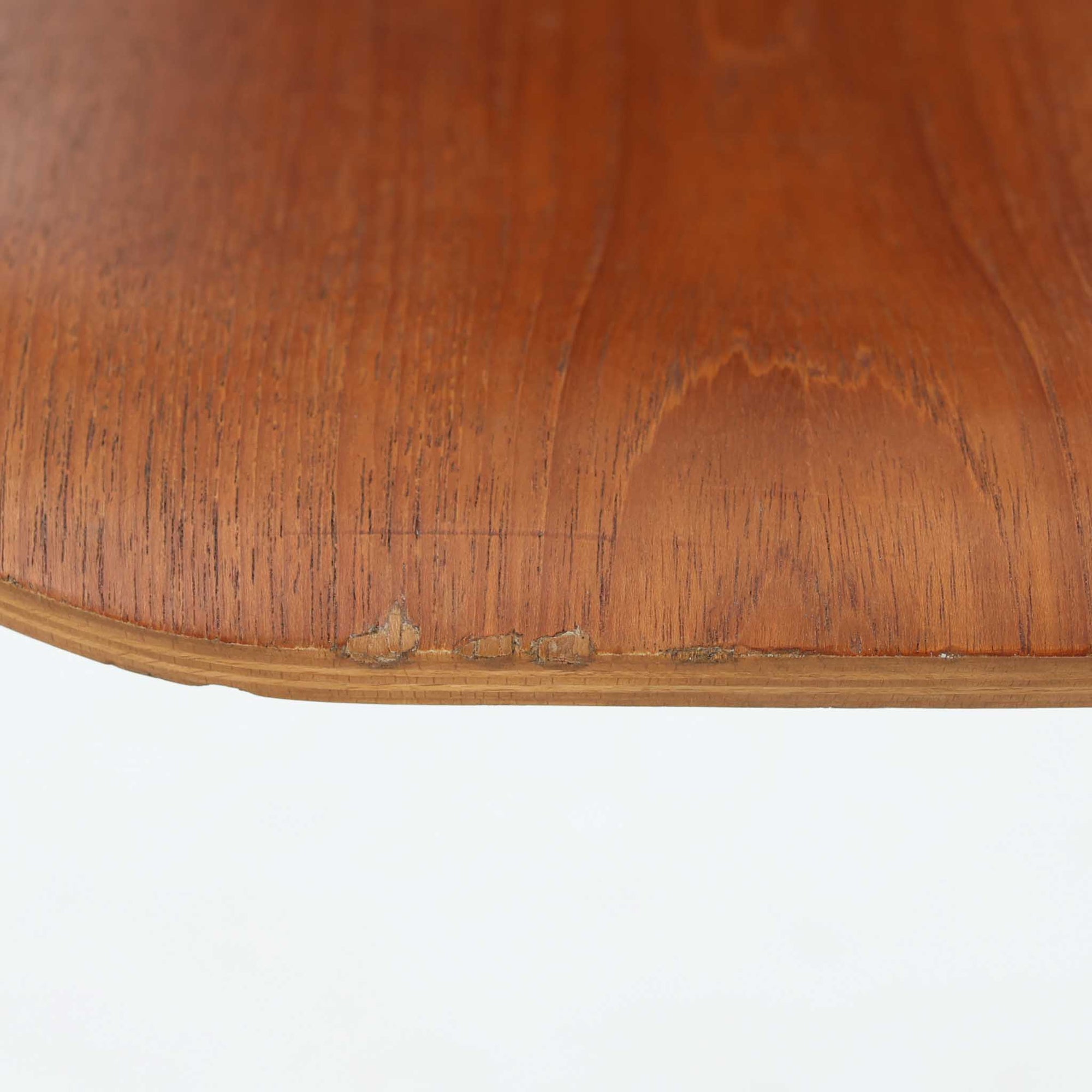 アルネ・ヤコブセンがデザインし、Fritz Hansenが製造した「T Chair」です。チーク材の成形合板による背座一体型のシェルは、背面上部を左右に広げた特徴的なシルエットと、身体に沿う緩やかな曲面が魅力。細身の金属脚との組み合わせが軽快で、ダイニングはもちろん、書斎や玄関のアクセントチェアにもおすすめです。美しい木目と時を重ねた風合い、合理的な構造に宿る北欧ビンテージらしい存在感を楽しめます。