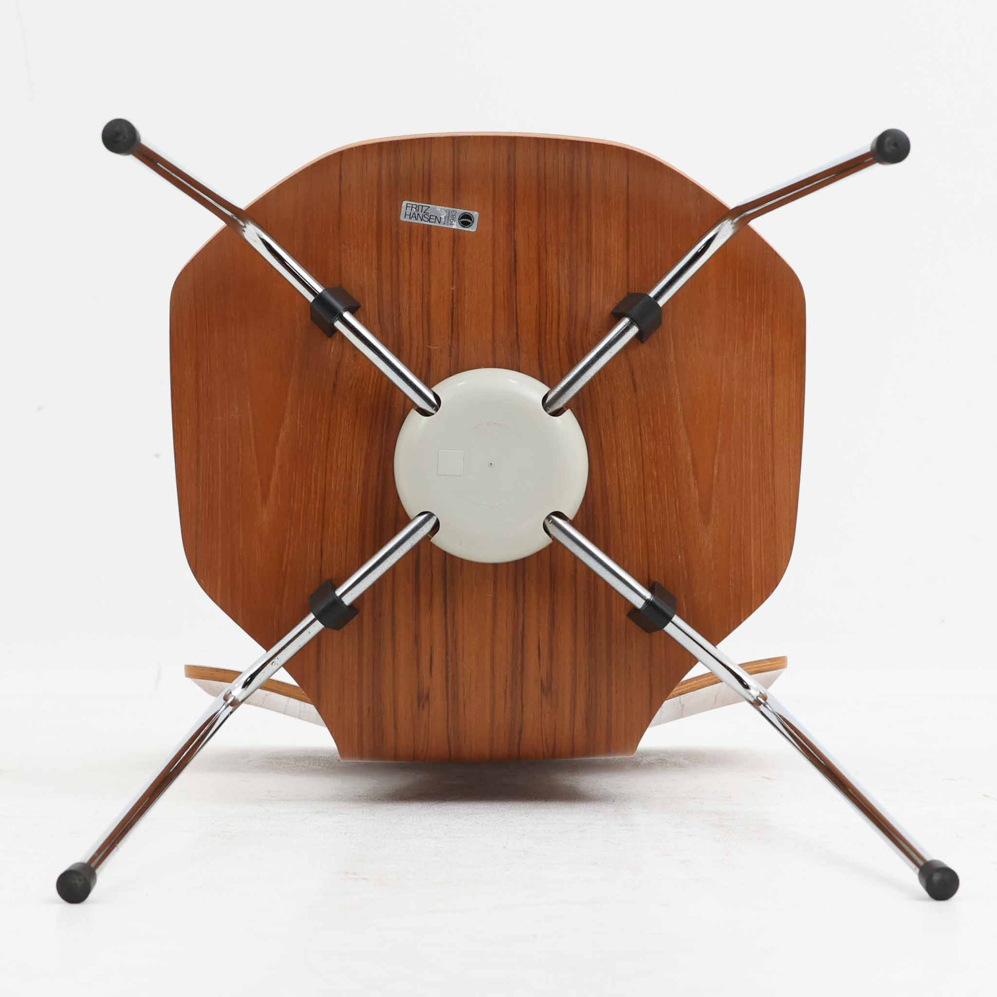 アルネ・ヤコブセンがデザインし、Fritz Hansenが製造した「T Chair」です。チーク材の成形合板による背座一体型のシェルは、背面上部を左右に広げた特徴的なシルエットと、身体に沿う緩やかな曲面が魅力。細身の金属脚との組み合わせが軽快で、ダイニングはもちろん、書斎や玄関のアクセントチェアにもおすすめです。美しい木目と時を重ねた風合い、合理的な構造に宿る北欧ビンテージらしい存在感を楽しめます。