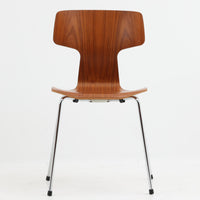 アルネ・ヤコブセンがデザインし、Fritz Hansenが製造した「T Chair」です。チーク材の成形合板による背座一体型のシェルは、背面上部を左右に広げた特徴的なシルエットと、身体に沿う緩やかな曲面が魅力。細身の金属脚との組み合わせが軽快で、ダイニングはもちろん、書斎や玄関のアクセントチェアにもおすすめです。美しい木目と時を重ねた風合い、合理的な構造に宿る北欧ビンテージらしい存在感を楽しめます。