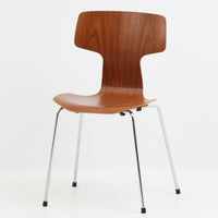 アルネ・ヤコブセンがデザインし、Fritz Hansenが製造した「T Chair」です。チーク材の成形合板による背座一体型のシェルは、背面上部を左右に広げた特徴的なシルエットと、身体に沿う緩やかな曲面が魅力。細身の金属脚との組み合わせが軽快で、ダイニングはもちろん、書斎や玄関のアクセントチェアにもおすすめです。美しい木目と時を重ねた風合い、合理的な構造に宿る北欧ビンテージらしい存在感を楽しめます。