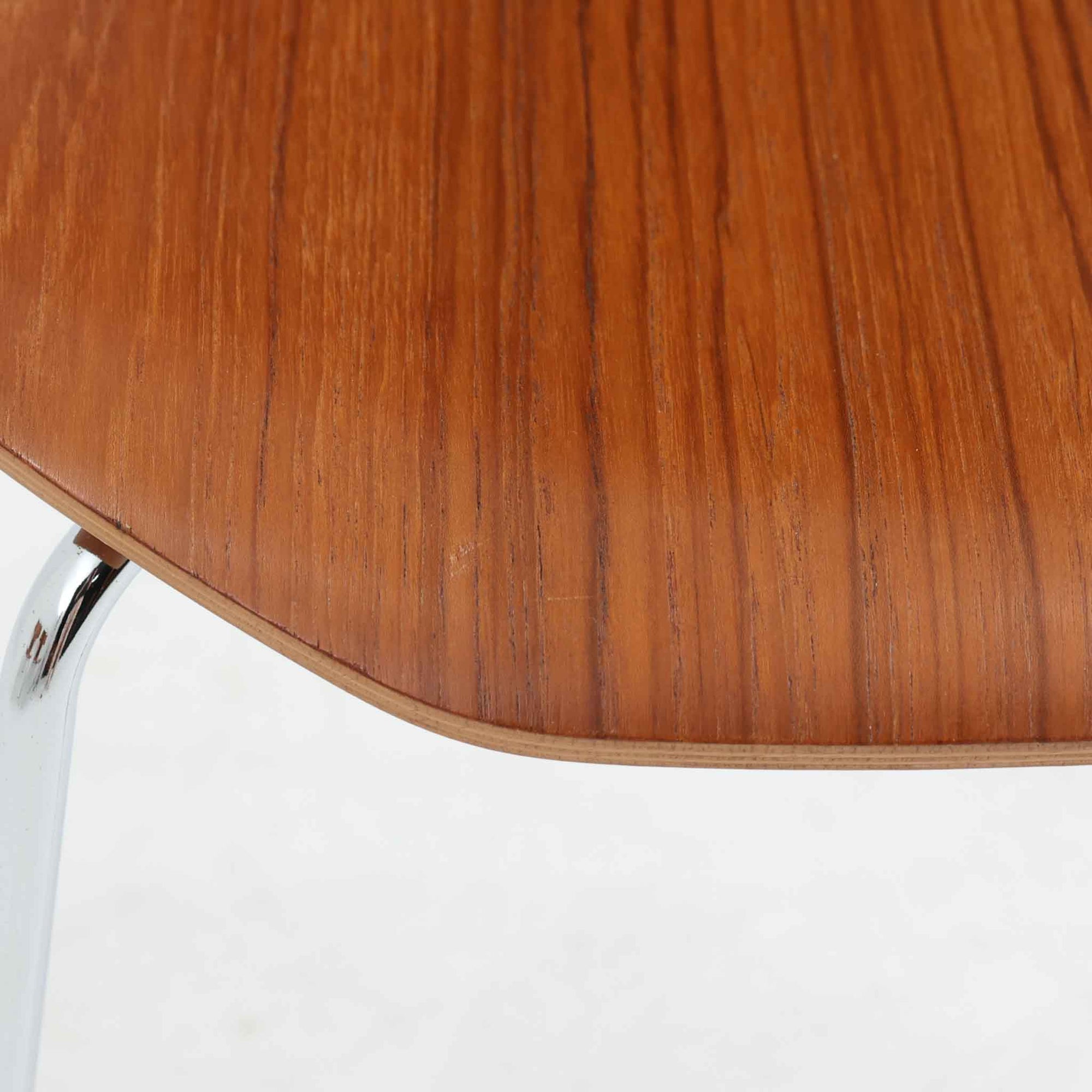 アルネ・ヤコブセンがデザインし、Fritz Hansenが製造した「T Chair」です。チーク材の成形合板による背座一体型のシェルは、背面上部を左右に広げた特徴的なシルエットと、身体に沿う緩やかな曲面が魅力。細身の金属脚との組み合わせが軽快で、ダイニングはもちろん、書斎や玄関のアクセントチェアにもおすすめです。美しい木目と時を重ねた風合い、合理的な構造に宿る北欧ビンテージらしい存在感を楽しめます。