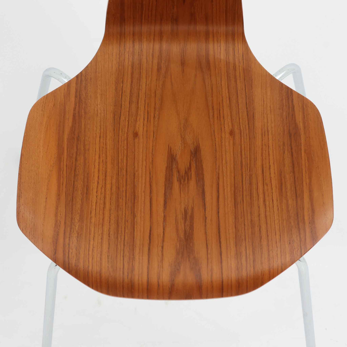 アルネ・ヤコブセンがデザインし、Fritz Hansenが製造した「T Chair」です。チーク材の成形合板による背座一体型のシェルは、背面上部を左右に広げた特徴的なシルエットと、身体に沿う緩やかな曲面が魅力。細身の金属脚との組み合わせが軽快で、ダイニングはもちろん、書斎や玄関のアクセントチェアにもおすすめです。美しい木目と時を重ねた風合い、合理的な構造に宿る北欧ビンテージらしい存在感を楽しめます。