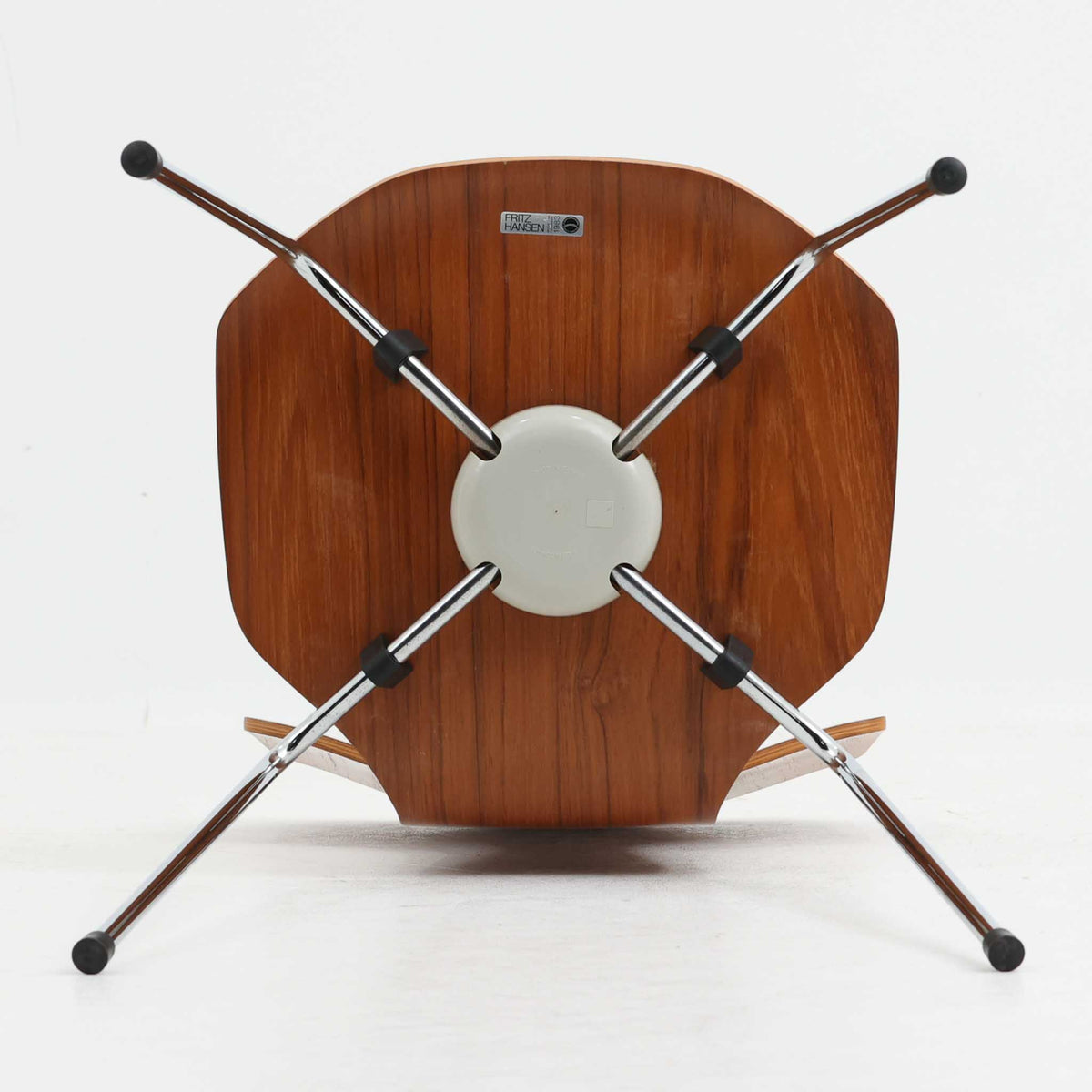アルネ・ヤコブセンがデザインし、Fritz Hansenが製造した「T Chair」です。チーク材の成形合板による背座一体型のシェルは、背面上部を左右に広げた特徴的なシルエットと、身体に沿う緩やかな曲面が魅力。細身の金属脚との組み合わせが軽快で、ダイニングはもちろん、書斎や玄関のアクセントチェアにもおすすめです。美しい木目と時を重ねた風合い、合理的な構造に宿る北欧ビンテージらしい存在感を楽しめます。