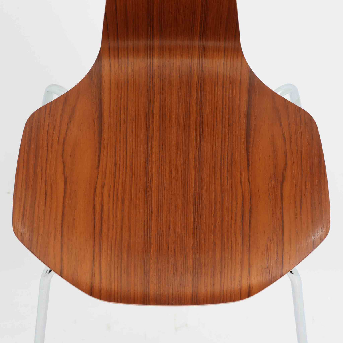 アルネ・ヤコブセンがデザインし、Fritz Hansenが製造した「T Chair」です。チーク材の成形合板による背座一体型のシェルは、背面上部を左右に広げた特徴的なシルエットと、身体に沿う緩やかな曲面が魅力。細身の金属脚との組み合わせが軽快で、ダイニングはもちろん、書斎や玄関のアクセントチェアにもおすすめです。美しい木目と時を重ねた風合い、合理的な構造に宿る北欧ビンテージらしい存在感を楽しめます。