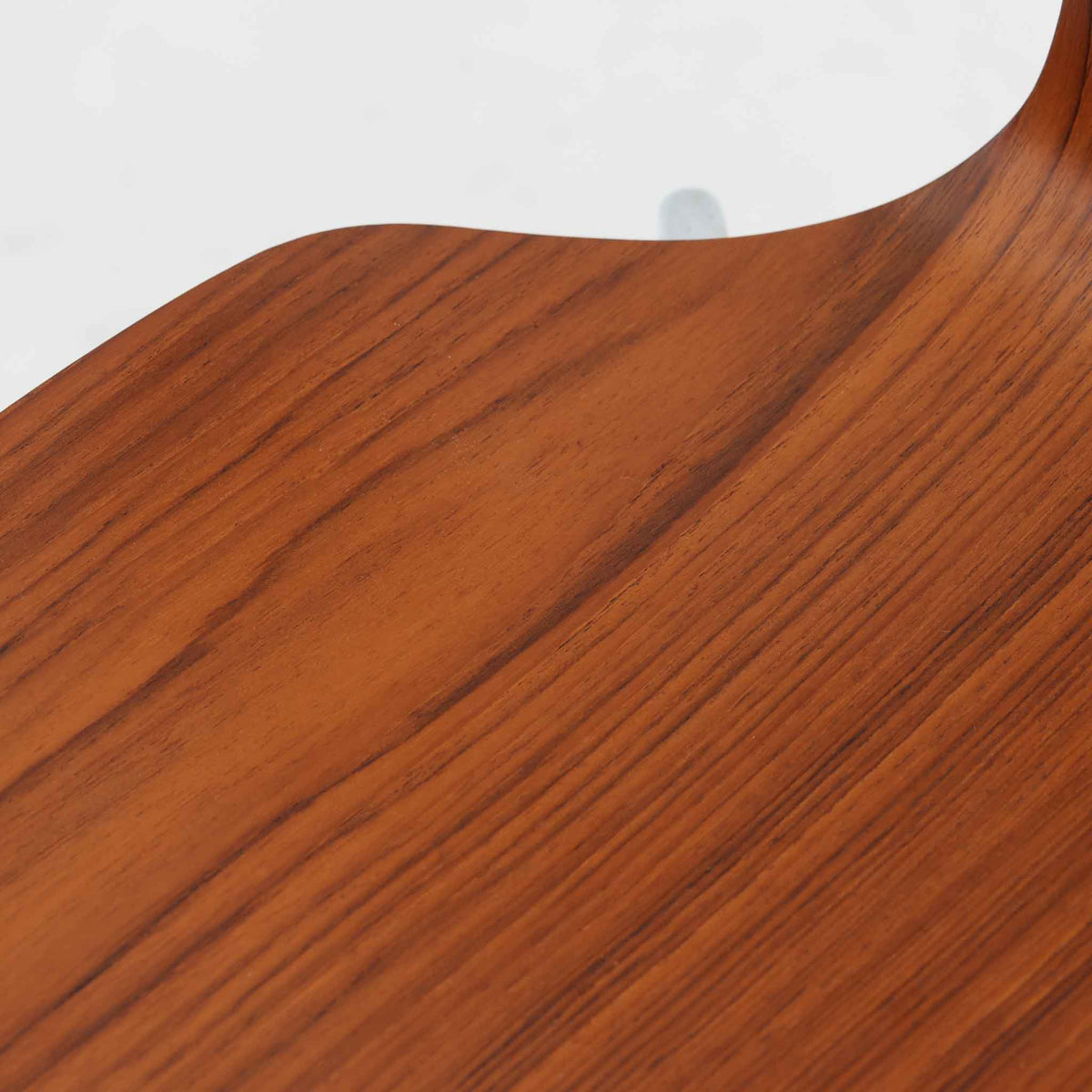 アルネ・ヤコブセンがデザインし、Fritz Hansenが製造した「T Chair」です。チーク材の成形合板による背座一体型のシェルは、背面上部を左右に広げた特徴的なシルエットと、身体に沿う緩やかな曲面が魅力。細身の金属脚との組み合わせが軽快で、ダイニングはもちろん、書斎や玄関のアクセントチェアにもおすすめです。美しい木目と時を重ねた風合い、合理的な構造に宿る北欧ビンテージらしい存在感を楽しめます。