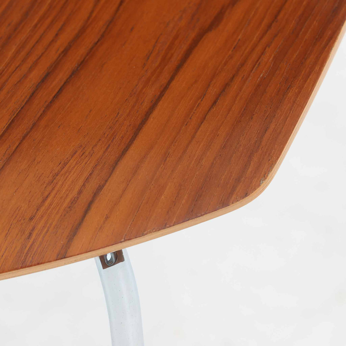 アルネ・ヤコブセンがデザインし、Fritz Hansenが製造した「T Chair」です。チーク材の成形合板による背座一体型のシェルは、背面上部を左右に広げた特徴的なシルエットと、身体に沿う緩やかな曲面が魅力。細身の金属脚との組み合わせが軽快で、ダイニングはもちろん、書斎や玄関のアクセントチェアにもおすすめです。美しい木目と時を重ねた風合い、合理的な構造に宿る北欧ビンテージらしい存在感を楽しめます。