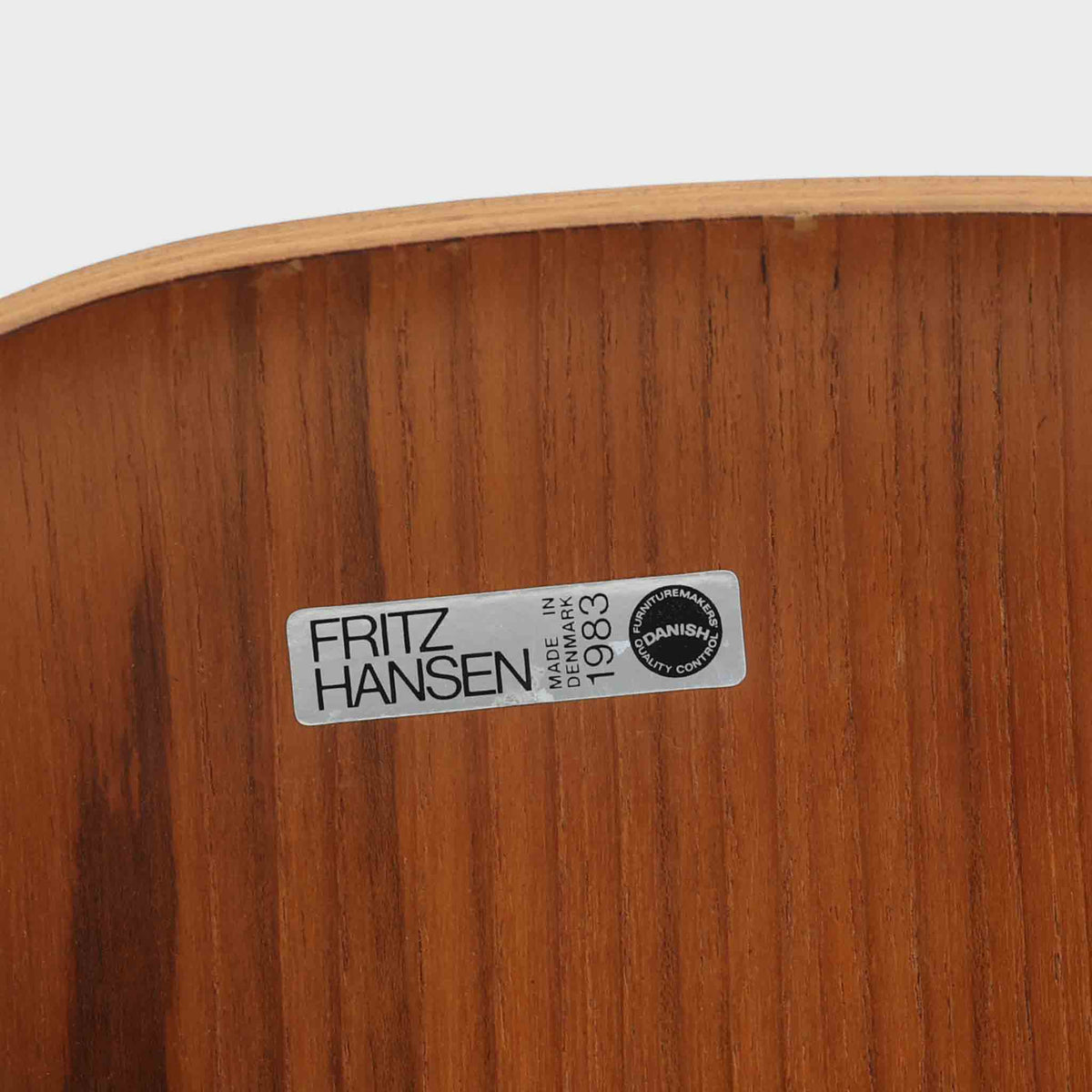 アルネ・ヤコブセンがデザインし、Fritz Hansenが製造した「T Chair」です。チーク材の成形合板による背座一体型のシェルは、背面上部を左右に広げた特徴的なシルエットと、身体に沿う緩やかな曲面が魅力。細身の金属脚との組み合わせが軽快で、ダイニングはもちろん、書斎や玄関のアクセントチェアにもおすすめです。美しい木目と時を重ねた風合い、合理的な構造に宿る北欧ビンテージらしい存在感を楽しめます。