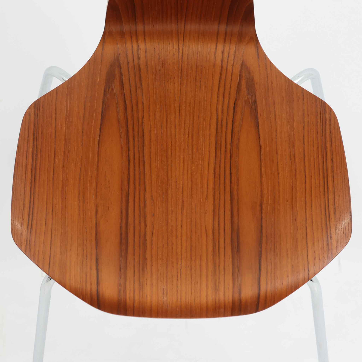 アルネ・ヤコブセンがデザインし、Fritz Hansenが製造した「T Chair」です。チーク材の成形合板による背座一体型のシェルは、背面上部を左右に広げた特徴的なシルエットと、身体に沿う緩やかな曲面が魅力。細身の金属脚との組み合わせが軽快で、ダイニングはもちろん、書斎や玄関のアクセントチェアにもおすすめです。美しい木目と時を重ねた風合い、合理的な構造に宿る北欧ビンテージらしい存在感を楽しめます。
