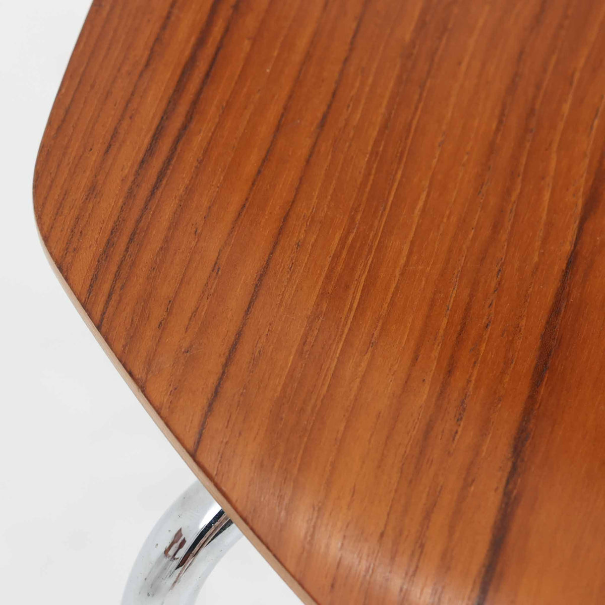 アルネ・ヤコブセンがデザインし、Fritz Hansenが製造した「T Chair」です。チーク材の成形合板による背座一体型のシェルは、背面上部を左右に広げた特徴的なシルエットと、身体に沿う緩やかな曲面が魅力。細身の金属脚との組み合わせが軽快で、ダイニングはもちろん、書斎や玄関のアクセントチェアにもおすすめです。美しい木目と時を重ねた風合い、合理的な構造に宿る北欧ビンテージらしい存在感を楽しめます。