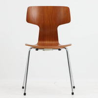 アルネ・ヤコブセンがデザインし、Fritz Hansenが製造した「T Chair」です。チーク材の成形合板による背座一体型のシェルは、背面上部を左右に広げた特徴的なシルエットと、身体に沿う緩やかな曲面が魅力。細身の金属脚との組み合わせが軽快で、ダイニングはもちろん、書斎や玄関のアクセントチェアにもおすすめです。美しい木目と時を重ねた風合い、合理的な構造に宿る北欧ビンテージらしい存在感を楽しめます。