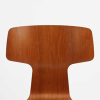 アルネ・ヤコブセンがデザインし、Fritz Hansenが製造した「T Chair」です。チーク材の成形合板による背座一体型のシェルは、背面上部を左右に広げた特徴的なシルエットと、身体に沿う緩やかな曲面が魅力。細身の金属脚との組み合わせが軽快で、ダイニングはもちろん、書斎や玄関のアクセントチェアにもおすすめです。美しい木目と時を重ねた風合い、合理的な構造に宿る北欧ビンテージらしい存在感を楽しめます。