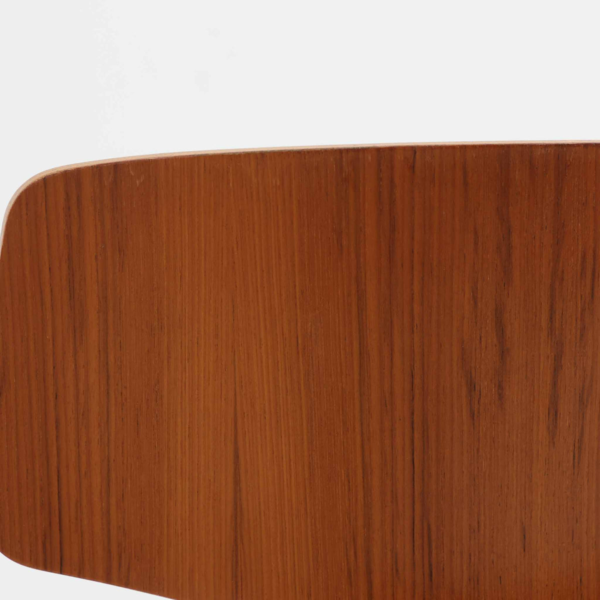 アルネ・ヤコブセンがデザインし、Fritz Hansenが製造した「T Chair」です。チーク材の成形合板による背座一体型のシェルは、背面上部を左右に広げた特徴的なシルエットと、身体に沿う緩やかな曲面が魅力。細身の金属脚との組み合わせが軽快で、ダイニングはもちろん、書斎や玄関のアクセントチェアにもおすすめです。美しい木目と時を重ねた風合い、合理的な構造に宿る北欧ビンテージらしい存在感を楽しめます。