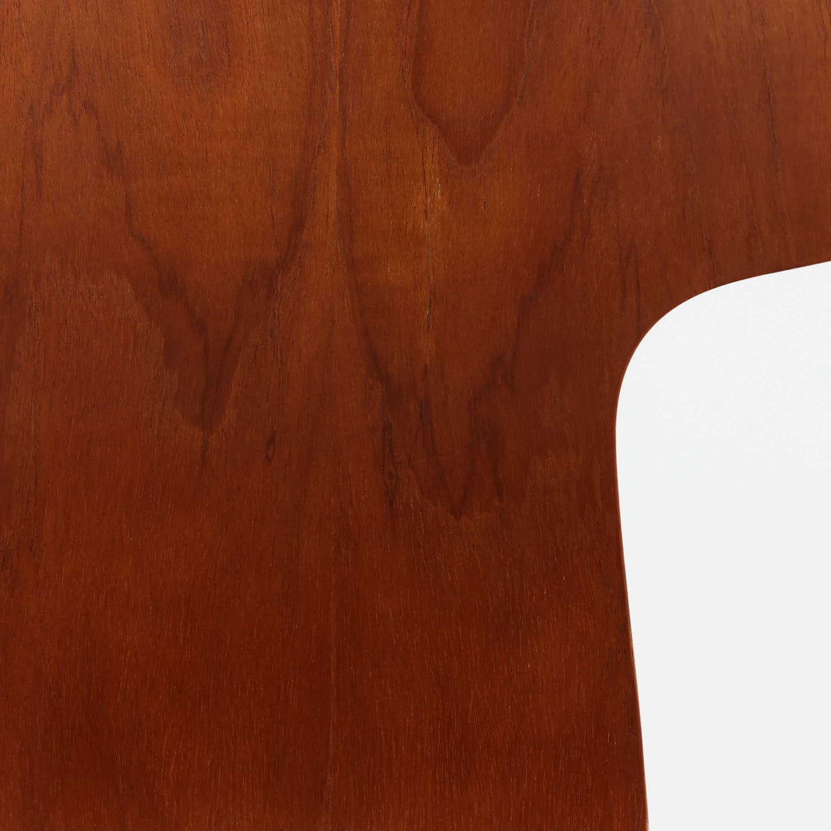 アルネ・ヤコブセンがデザインし、Fritz Hansenが製造した「T Chair」です。チーク材の成形合板による背座一体型のシェルは、背面上部を左右に広げた特徴的なシルエットと、身体に沿う緩やかな曲面が魅力。細身の金属脚との組み合わせが軽快で、ダイニングはもちろん、書斎や玄関のアクセントチェアにもおすすめです。美しい木目と時を重ねた風合い、合理的な構造に宿る北欧ビンテージらしい存在感を楽しめます。