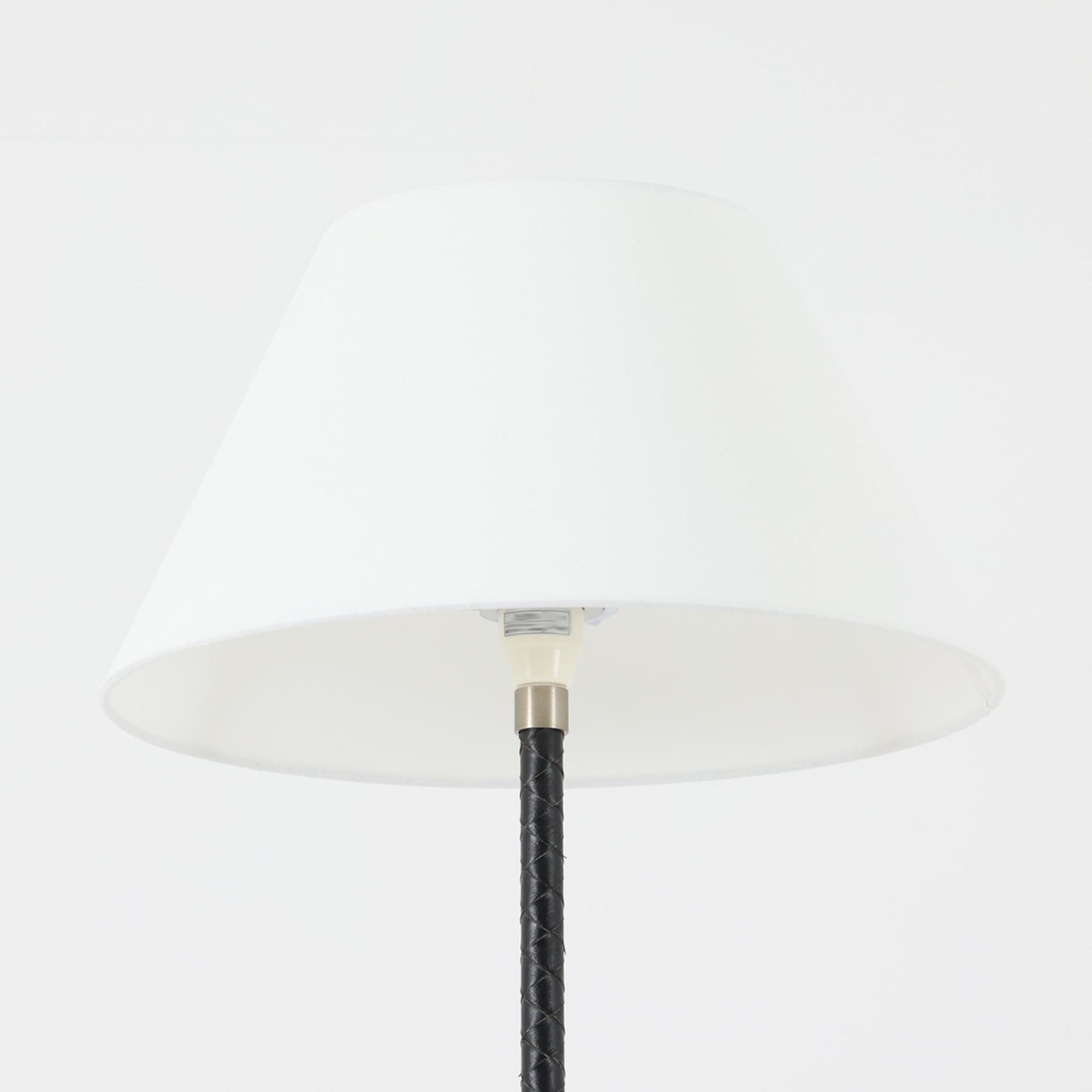 Jo Hammerborgがデザインを手がけ、Fog &amp; Morup社より発表された「Flet」フロアランプは、スチール支柱に丁寧に編み込まれたブラックレザーと、上品なリネンシェードのコントラストが美しい北欧ビンテージ照明です。高さ155cmとすっきりとした佇まいで、空間に程よい存在感をもたらします。経年によるレザーの風合いやシェード越しの柔らかな光が、空間に落ち着いた雰囲気と温もりを加えてくれる一台です。