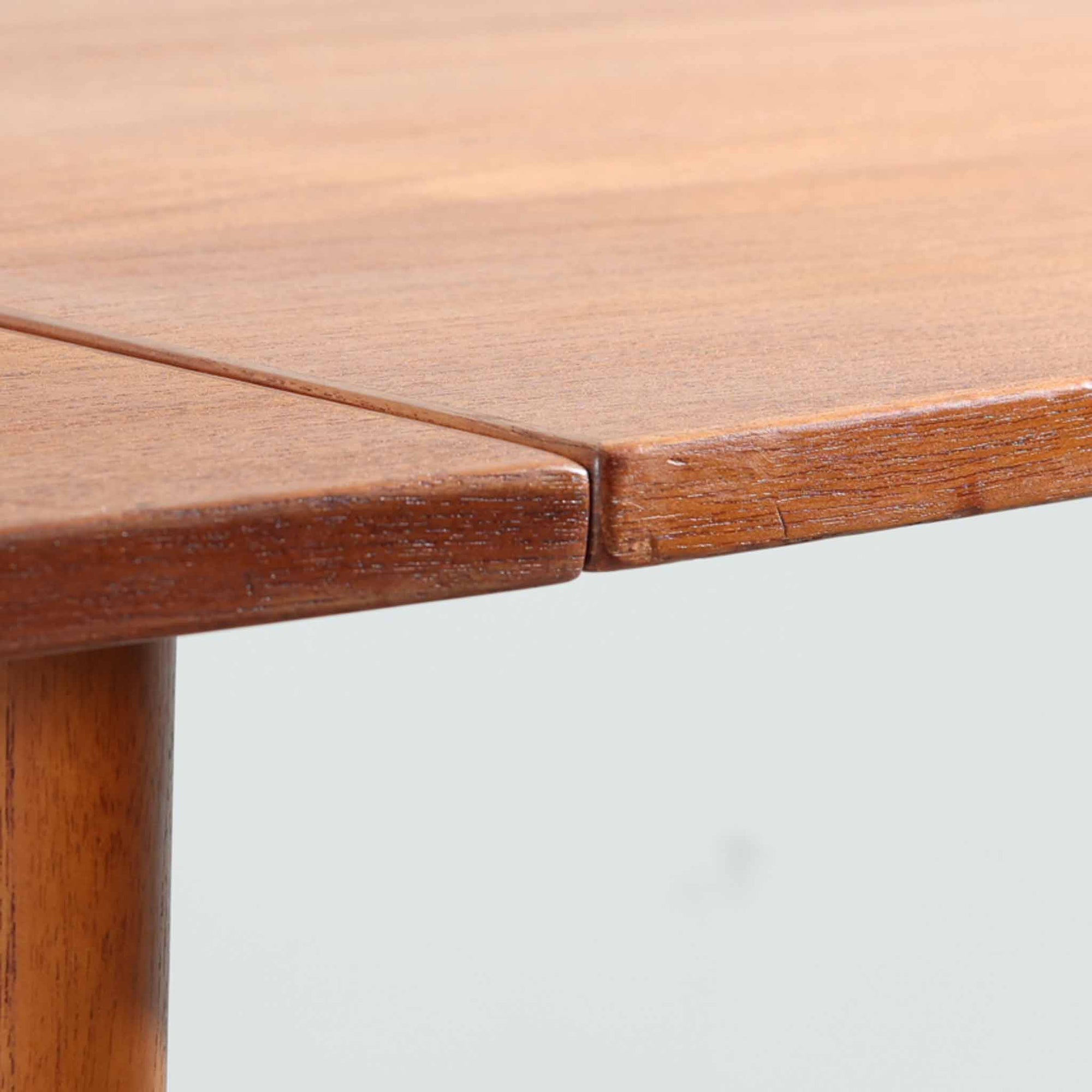 デンマークのHundevad &amp; Co社によるバタフライ式のダイニングテーブルは、希少なチーク材を使用した上品な佇まいと、幅133cmから195cmへと片側の拡張板でサイズ調整が可能な機能性が魅力の一台です。普段はコンパクトに、必要に応じて天板を広げて使える設計は、日常から来客時まで幅広く活躍します。直線的なフレームと繊細な脚部が調和し、空間に北欧ビンテージらしい落ち着きと温かみを添えてくれます。