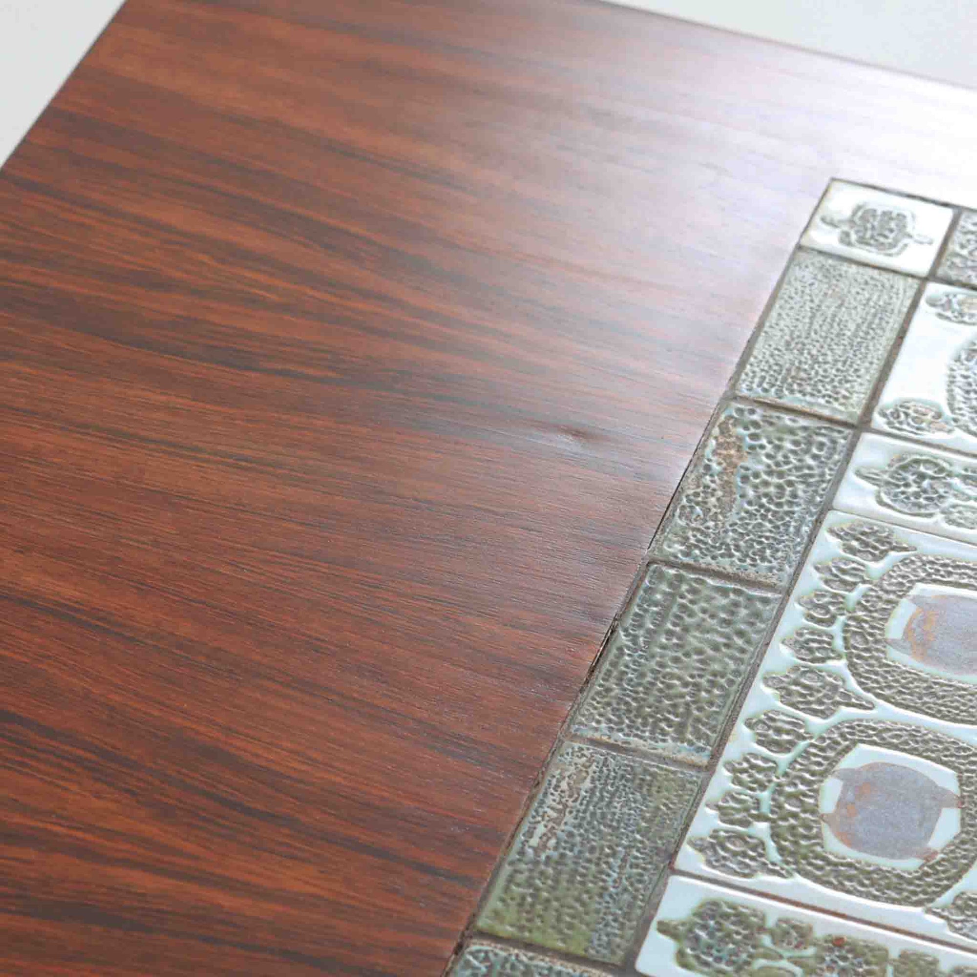 デンマークの名工Severin Hansen Jr.が手がけたHaslev社製のセンターテーブルは、希少なローズウッド材とRoyal CopenhagenのTeneraシリーズの陶板を組み合わせた贅沢な一台です。滑らかな天板に埋め込まれたタイルは深みのある釉薬と抽象的な文様が美しく、彫刻的な脚部のシャープなラインと調和し、上質な空間を演出します。奥行のあるデザインはリビングの主役として、またアートピースのようにお楽しみいただけます。