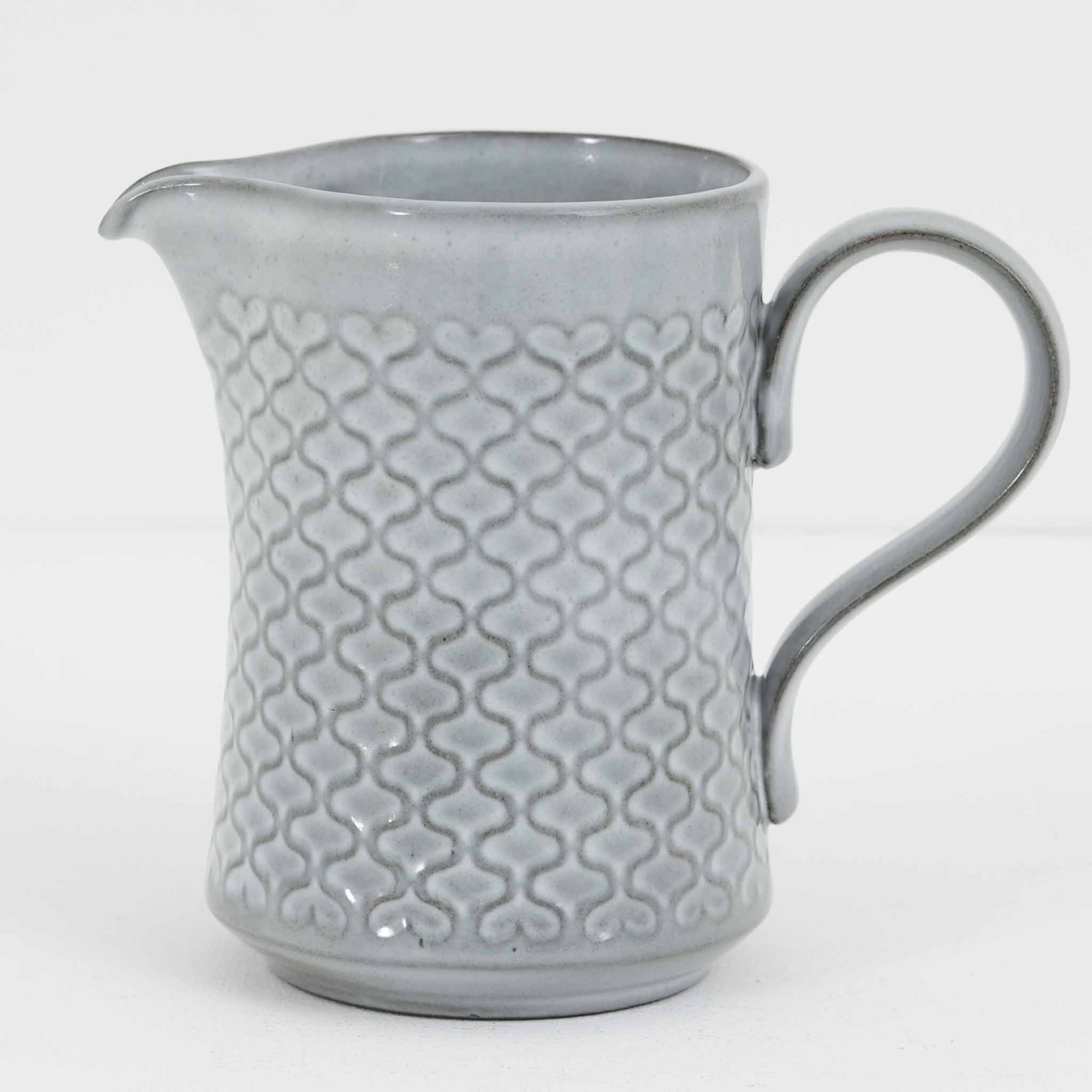 デンマークを代表するデザイナー、イェンス・H・クイストゴーによる「Cordial（コーディアル）」シリーズのヴィンテージ・ミルクジャグ（ピッチャー）です。1960年代にKronjydenから制作が始まったシリーズは、その後Nissen、Bing&Grondahlと引き継がれ長く愛されたシリーズとなりました。淡いグレーのストーンウェアにハートを連想させる繊細な型押し模様が施されており、デンマークではスウェーデンやフィンランドの陶器メーカーと並んで今でも非常に人気のある商品となります。