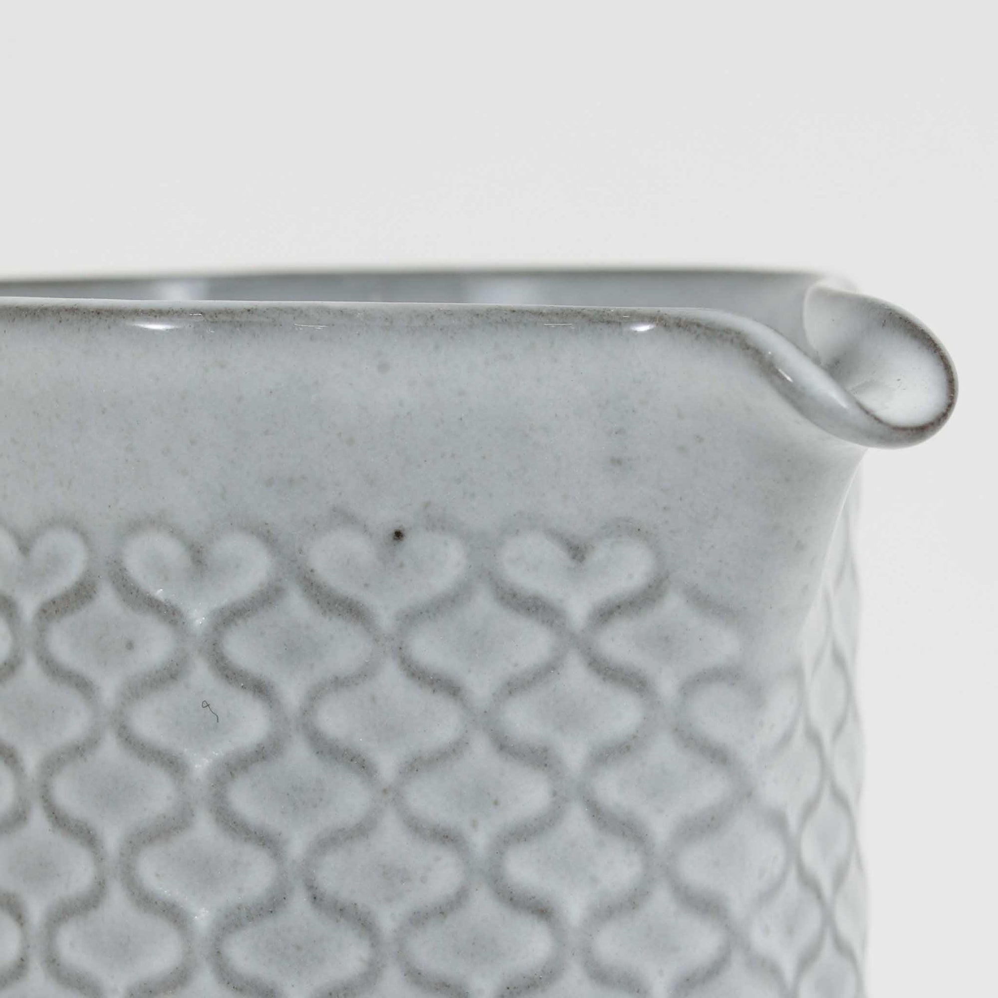 デンマークを代表するデザイナー、イェンス・H・クイストゴーによる「Cordial（コーディアル）」シリーズのヴィンテージ・ミルクジャグ（ピッチャー）です。1960年代にKronjydenから制作が始まったシリーズは、その後Nissen、Bing&amp;Grondahlと引き継がれ長く愛されたシリーズとなりました。淡いグレーのストーンウェアにハートを連想させる繊細な型押し模様が施されており、デンマークではスウェーデンやフィンランドの陶器メーカーと並んで今でも非常に人気のある商品となります。