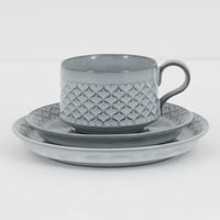 デンマークを代表するデザイナー、イェンス・H・クイストゴーによる「Cordial（コーディアル）」シリーズのヴィンテージ・トリオセット（ティーカップ、ソーサー、プレート）です。1960年代にKronjydenから制作が始まったシリーズは、その後Nissen、Bing&Grondahlと引き継がれ長く愛されたシリーズとなりました。淡いグレーのストーンウェアにハートを連想させる繊細な型押し模様が施されており、デンマークではスウェーデンやフィンランドの陶器メーカーと並んで今でも非常に人気のある商品となります。