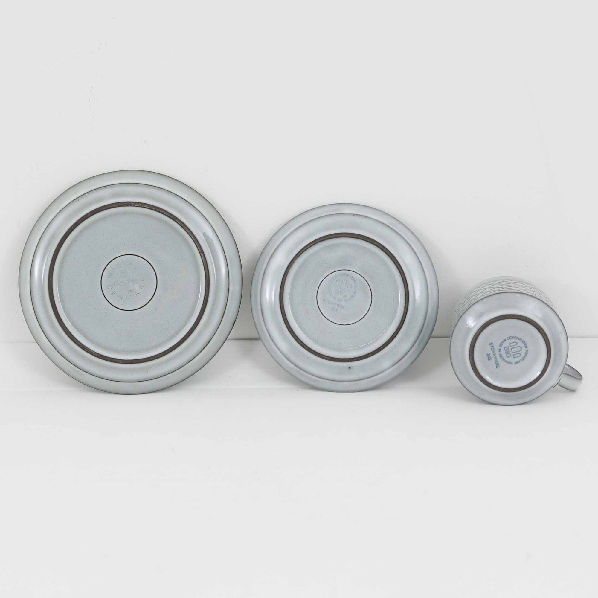 デンマークを代表するデザイナー、イェンス・H・クイストゴーによる「Cordial（コーディアル）」シリーズのヴィンテージ・トリオセット（ティーカップ、ソーサー、プレート）です。1960年代にKronjydenから制作が始まったシリーズは、その後Nissen、Bing&amp;Grondahlと引き継がれ長く愛されたシリーズとなりました。淡いグレーのストーンウェアにハートを連想させる繊細な型押し模様が施されており、デンマークではスウェーデンやフィンランドの陶器メーカーと並んで今でも非常に人気のある商品となります。