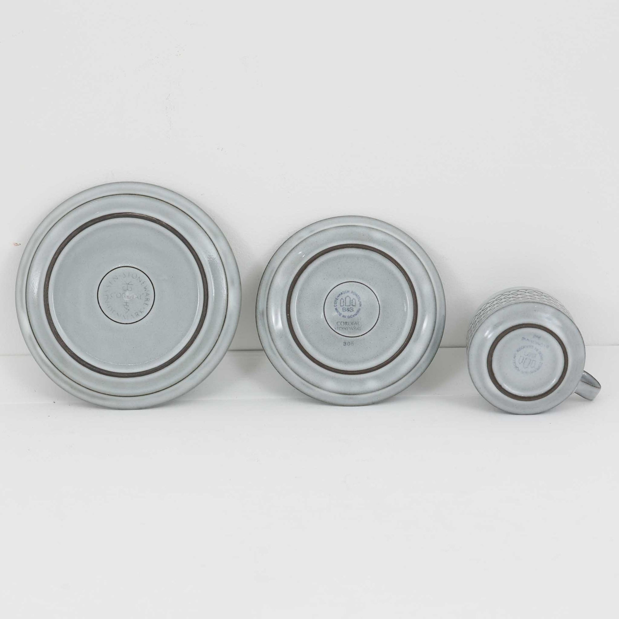 デンマークを代表するデザイナー、イェンス・H・クイストゴーによる「Cordial（コーディアル）」シリーズのヴィンテージ・トリオセット（ティーカップ、ソーサー、プレート）です。1960年代にKronjydenから制作が始まったシリーズは、その後Nissen、Bing&amp;Grondahlと引き継がれ長く愛されたシリーズとなりました。淡いグレーのストーンウェアにハートを連想させる繊細な型押し模様が施されており、デンマークではスウェーデンやフィンランドの陶器メーカーと並んで今でも非常に人気のある商品となります。