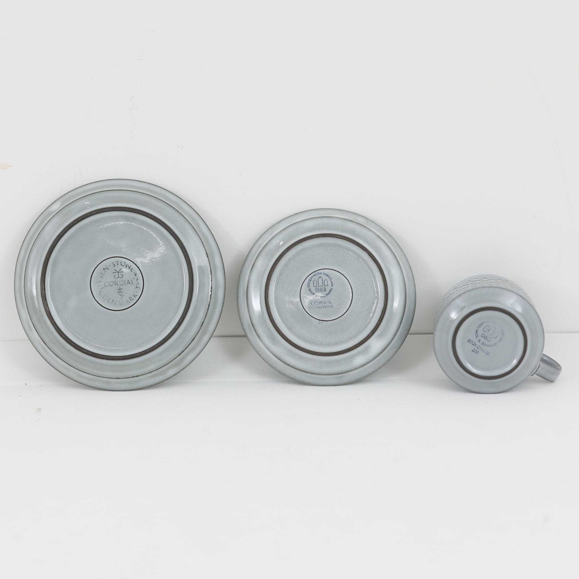 デンマークを代表するデザイナー、イェンス・H・クイストゴーによる「Cordial（コーディアル）」シリーズのヴィンテージ・トリオセット（ティーカップ、ソーサー、プレート）です。1960年代にKronjydenから制作が始まったシリーズは、その後Nissen、Bing&amp;Grondahlと引き継がれ長く愛されたシリーズとなりました。淡いグレーのストーンウェアにハートを連想させる繊細な型押し模様が施されており、デンマークではスウェーデンやフィンランドの陶器メーカーと並んで今でも非常に人気のある商品となります。