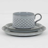 デンマークを代表するデザイナー、イェンス・H・クイストゴーによる「Cordial（コーディアル）」シリーズのヴィンテージ・トリオセット（ティーカップ、ソーサー、プレート）です。1960年代にKronjydenから制作が始まったシリーズは、その後Nissen、Bing&Grondahlと引き継がれ長く愛されたシリーズとなりました。淡いグレーのストーンウェアにハートを連想させる繊細な型押し模様が施されており、デンマークではスウェーデンやフィンランドの陶器メーカーと並んで今でも非常に人気のある商品となります。