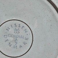 デンマークを代表するデザイナー、イェンス・H・クイストゴーによる「Cordial（コーディアル）」シリーズのヴィンテージ・トリオセット（ティーカップ、ソーサー、プレート）です。1960年代にKronjydenから制作が始まったシリーズは、その後Nissen、Bing&Grondahlと引き継がれ長く愛されたシリーズとなりました。淡いグレーのストーンウェアにハートを連想させる繊細な型押し模様が施されており、デンマークではスウェーデンやフィンランドの陶器メーカーと並んで今でも非常に人気のある商品となります。