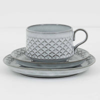 デンマークを代表するデザイナー、イェンス・H・クイストゴーによる「Cordial（コーディアル）」シリーズのヴィンテージ・トリオセット（ティーカップ、ソーサー、プレート）です。1960年代にKronjydenから制作が始まったシリーズは、その後Nissen、Bing&Grondahlと引き継がれ長く愛されたシリーズとなりました。淡いグレーのストーンウェアにハートを連想させる繊細な型押し模様が施されており、デンマークではスウェーデンやフィンランドの陶器メーカーと並んで今でも非常に人気のある商品となります。