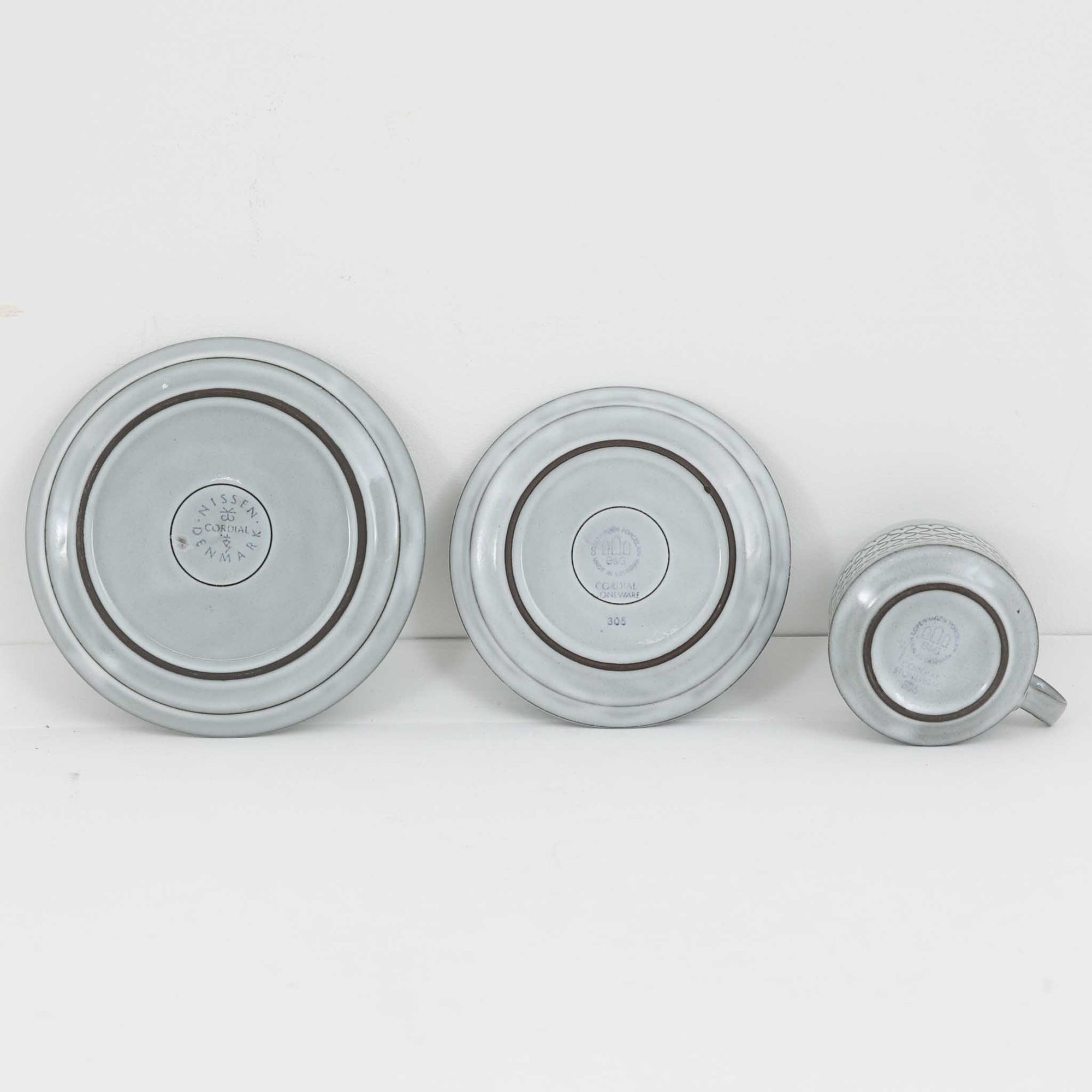 デンマークを代表するデザイナー、イェンス・H・クイストゴーによる「Cordial（コーディアル）」シリーズのヴィンテージ・トリオセット（ティーカップ、ソーサー、プレート）です。1960年代にKronjydenから制作が始まったシリーズは、その後Nissen、Bing&amp;Grondahlと引き継がれ長く愛されたシリーズとなりました。淡いグレーのストーンウェアにハートを連想させる繊細な型押し模様が施されており、デンマークではスウェーデンやフィンランドの陶器メーカーと並んで今でも非常に人気のある商品となります。