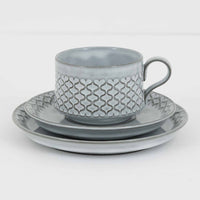 デンマークを代表するデザイナー、イェンス・H・クイストゴーによる「Cordial（コーディアル）」シリーズのヴィンテージ・トリオセット（ティーカップ、ソーサー、プレート）です。1960年代にKronjydenから制作が始まったシリーズは、その後Nissen、Bing&Grondahlと引き継がれ長く愛されたシリーズとなりました。淡いグレーのストーンウェアにハートを連想させる繊細な型押し模様が施されており、デンマークではスウェーデンやフィンランドの陶器メーカーと並んで今でも非常に人気のある商品となります。