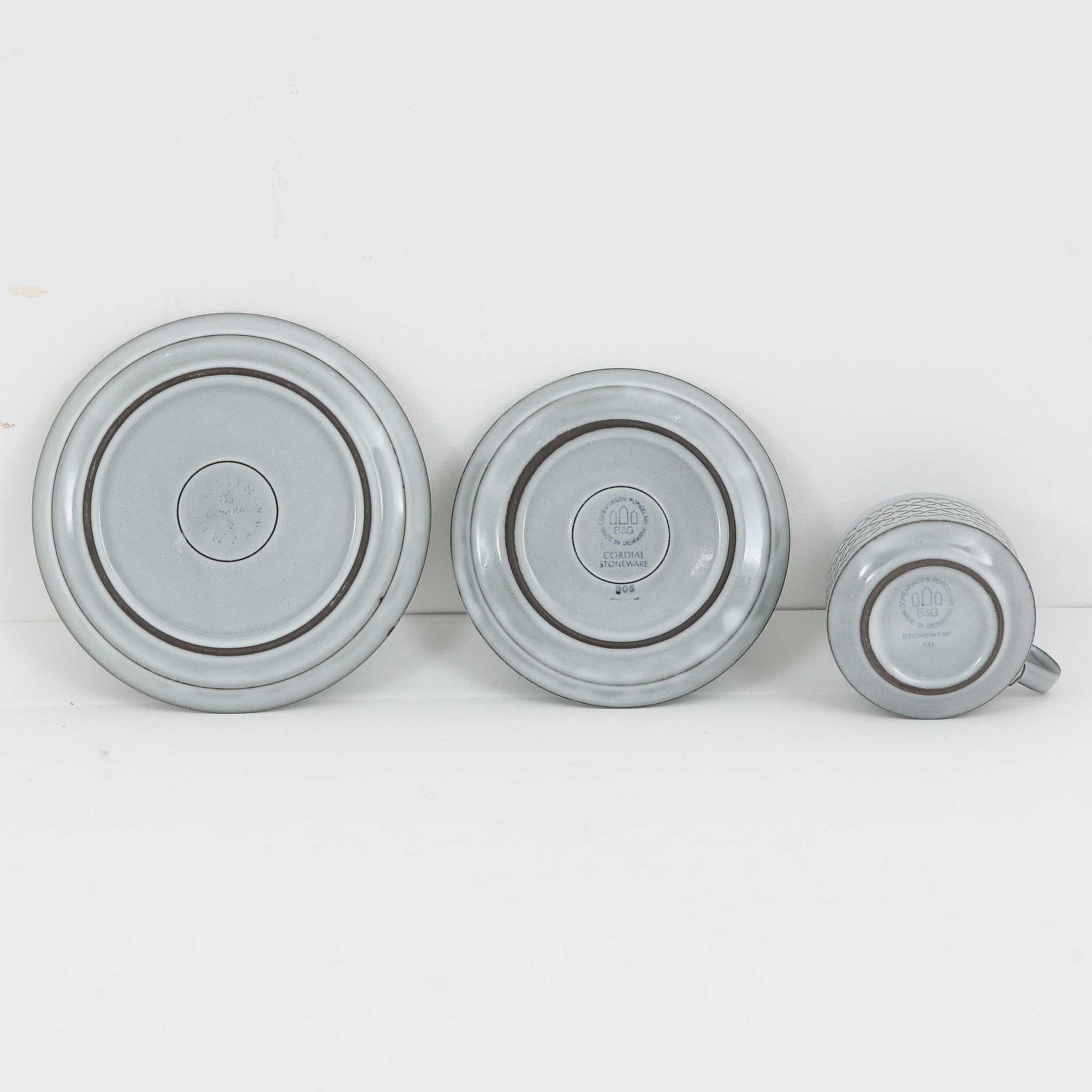 デンマークを代表するデザイナー、イェンス・H・クイストゴーによる「Cordial（コーディアル）」シリーズのヴィンテージ・トリオセット（ティーカップ、ソーサー、プレート）です。1960年代にKronjydenから制作が始まったシリーズは、その後Nissen、Bing&amp;Grondahlと引き継がれ長く愛されたシリーズとなりました。淡いグレーのストーンウェアにハートを連想させる繊細な型押し模様が施されており、デンマークではスウェーデンやフィンランドの陶器メーカーと並んで今でも非常に人気のある商品となります。