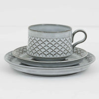 デンマークを代表するデザイナー、イェンス・H・クイストゴーによる「Cordial（コーディアル）」シリーズのヴィンテージ・トリオセット（ティーカップ、ソーサー、プレート）です。1960年代にKronjydenから制作が始まったシリーズは、その後Nissen、Bing&Grondahlと引き継がれ長く愛されたシリーズとなりました。淡いグレーのストーンウェアにハートを連想させる繊細な型押し模様が施されており、デンマークではスウェーデンやフィンランドの陶器メーカーと並んで今でも非常に人気のある商品となります。