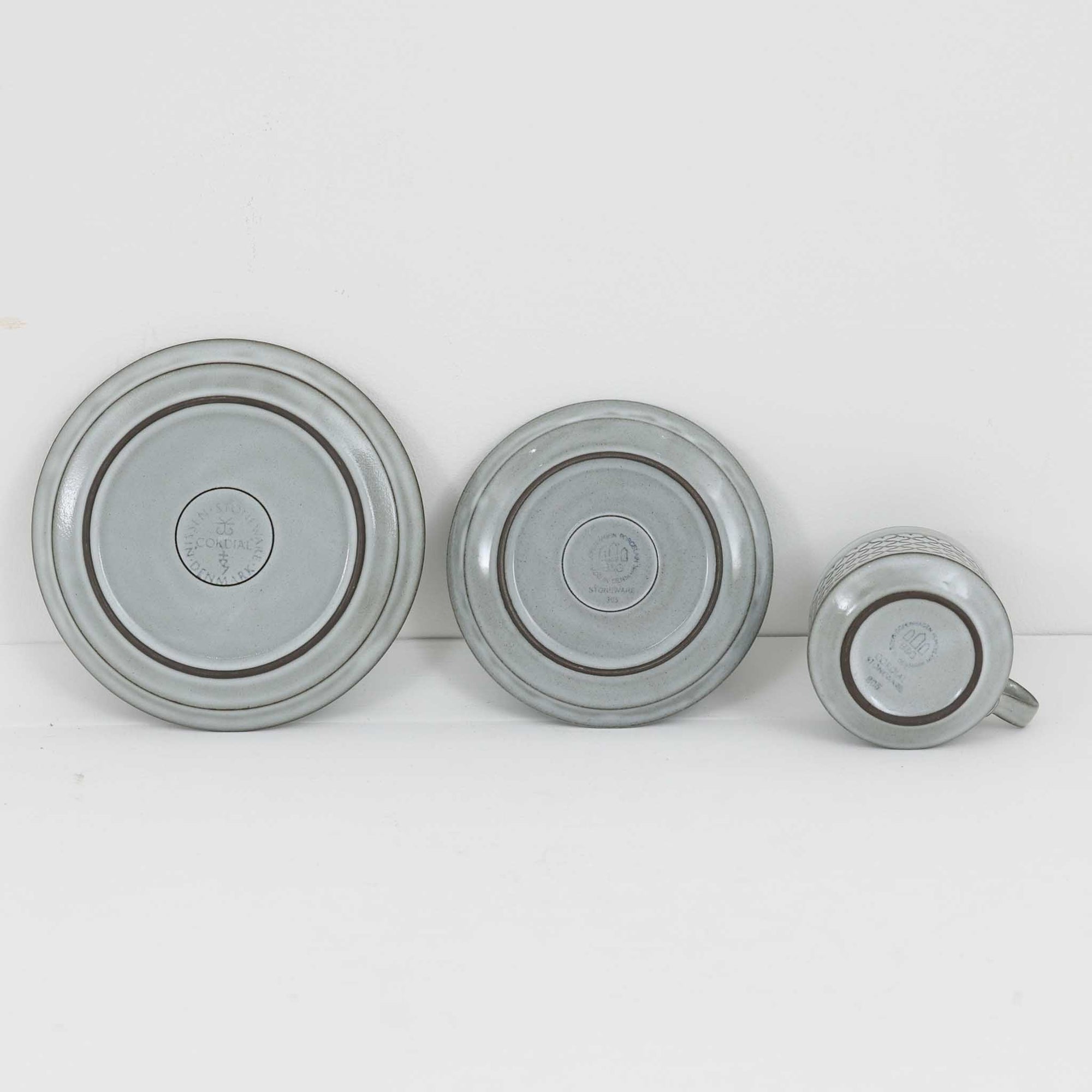 デンマークを代表するデザイナー、イェンス・H・クイストゴーによる「Cordial（コーディアル）」シリーズのヴィンテージ・トリオセット（ティーカップ、ソーサー、プレート）です。1960年代にKronjydenから制作が始まったシリーズは、その後Nissen、Bing&amp;Grondahlと引き継がれ長く愛されたシリーズとなりました。淡いグレーのストーンウェアにハートを連想させる繊細な型押し模様が施されており、デンマークではスウェーデンやフィンランドの陶器メーカーと並んで今でも非常に人気のある商品となります。