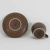 デンマークを代表するデザイナー、イェンス・H・クイストゴーによる「Azur（アズール）」シリーズのヴィンテージカッププ&ソーサーです。1960年代にKronjydenから制作が始まったシリーズは、その後Nissen、Bing&Grondahlと引き継がれ長く愛されたシリーズとなりました。落ち着いたブラウンとプラム色の繊細なフラワーレリーフが施されたストーンウェアは、自然の美しさを食卓にそっと運びます。特にAzurシリーズはヴィンテージ市場でも流通量が極めて少なく高価な逸品となります。