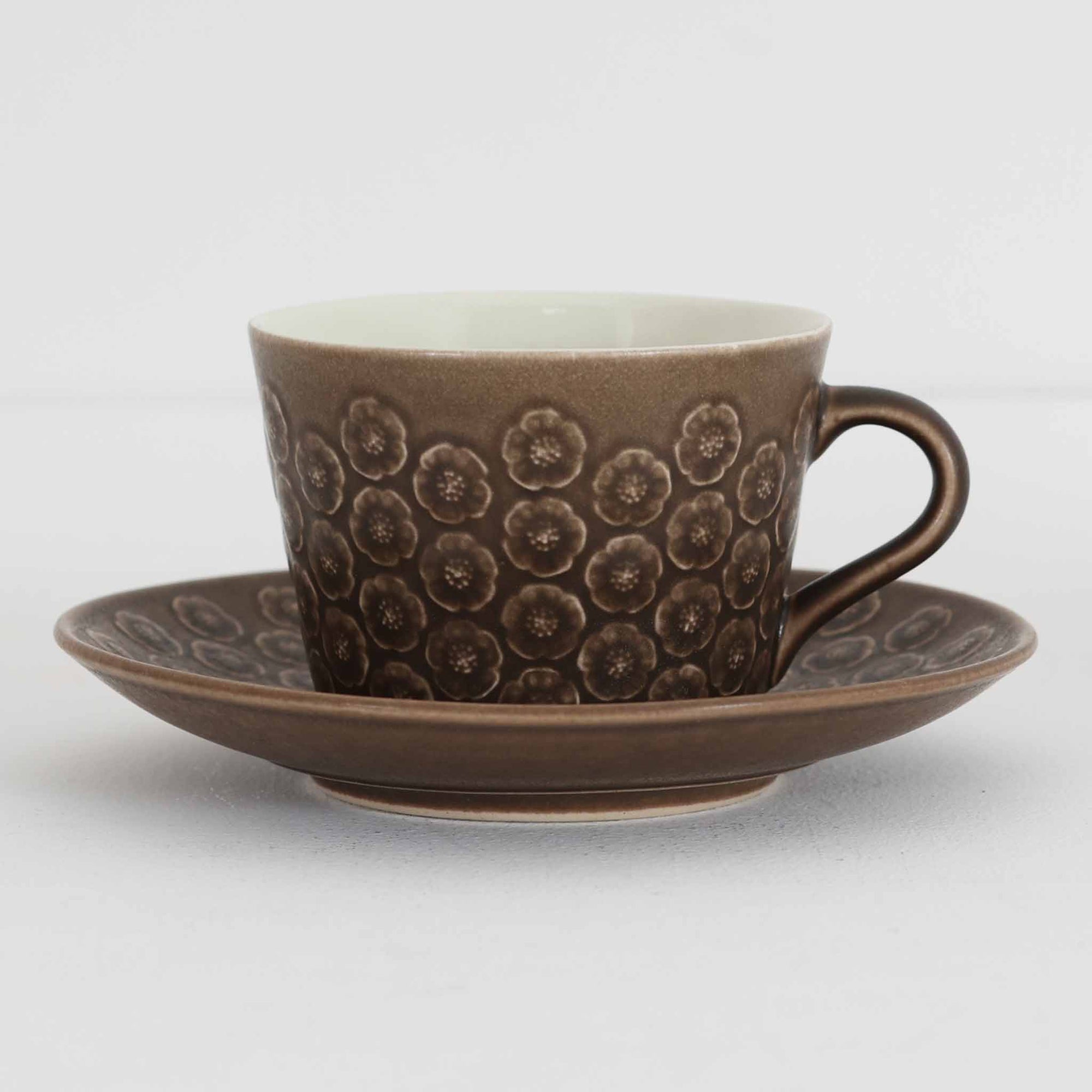 デンマークを代表するデザイナー、イェンス・H・クイストゴーによる「Azur（アズール）」シリーズのヴィンテージカッププ&ソーサーです。1960年代にKronjydenから制作が始まったシリーズは、その後Nissen、Bing&Grondahlと引き継がれ長く愛されたシリーズとなりました。落ち着いたブラウンとプラム色の繊細なフラワーレリーフが施されたストーンウェアは、自然の美しさを食卓にそっと運びます。特にAzurシリーズはヴィンテージ市場でも流通量が極めて少なく高価な逸品となります。