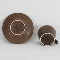 デンマークを代表するデザイナー、イェンス・H・クイストゴーによる「Azur（アズール）」シリーズのヴィンテージカッププ&ソーサーです。1960年代にKronjydenから制作が始まったシリーズは、その後Nissen、Bing&Grondahlと引き継がれ長く愛されたシリーズとなりました。落ち着いたブラウンとプラム色の繊細なフラワーレリーフが施されたストーンウェアは、自然の美しさを食卓にそっと運びます。特にAzurシリーズはヴィンテージ市場でも流通量が極めて少なく高価な逸品となります。