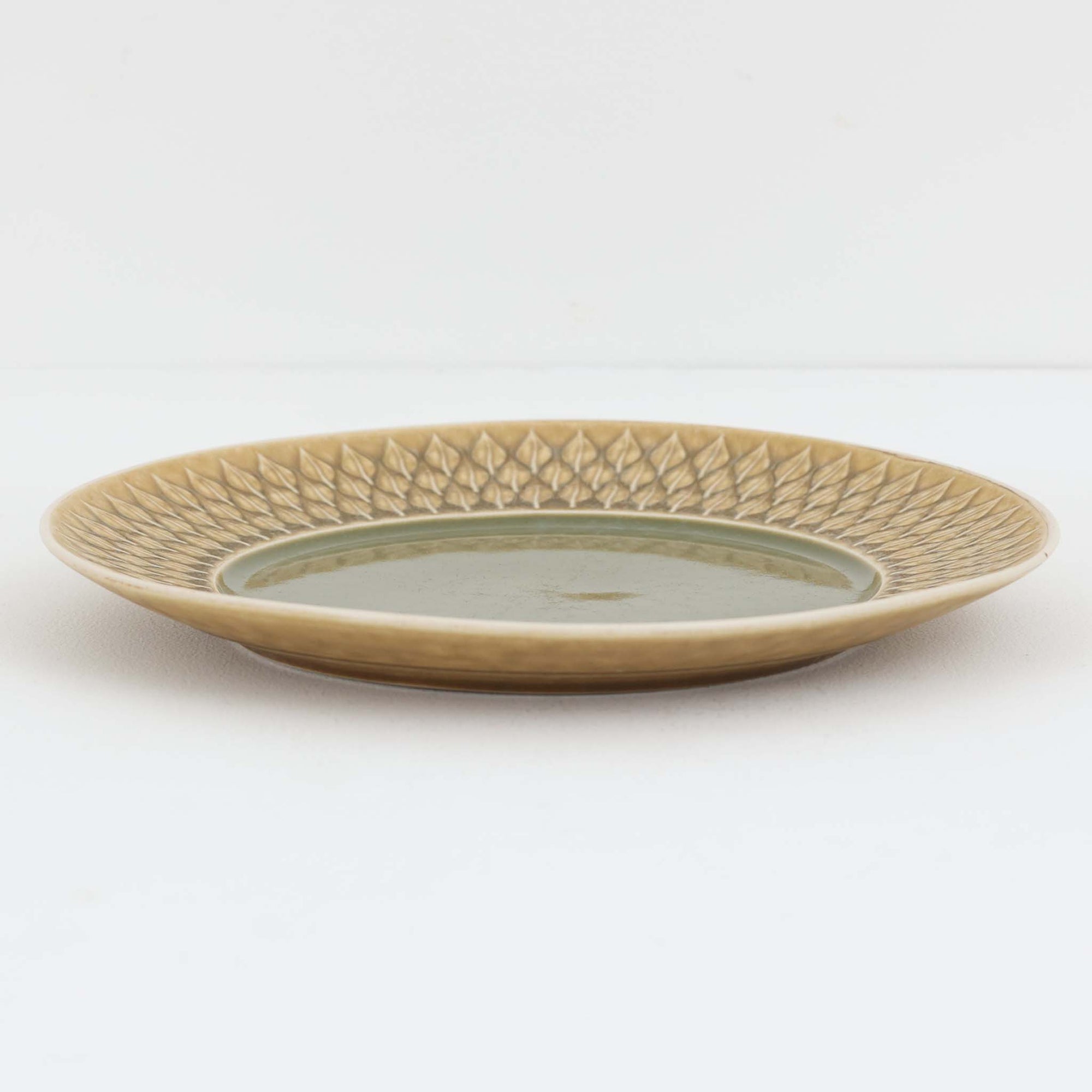 デンマークを代表するデザイナー、イェンス・H・クイストゴーによる「Relief（レリーフ）」シリーズのプレートです。一面に施されたレリーフ装飾が、自然の息吹を感じさせます。デンマークではスウェーデンやフィンランドの陶器メーカーと並んで今でも非常に人気のある商品となります。