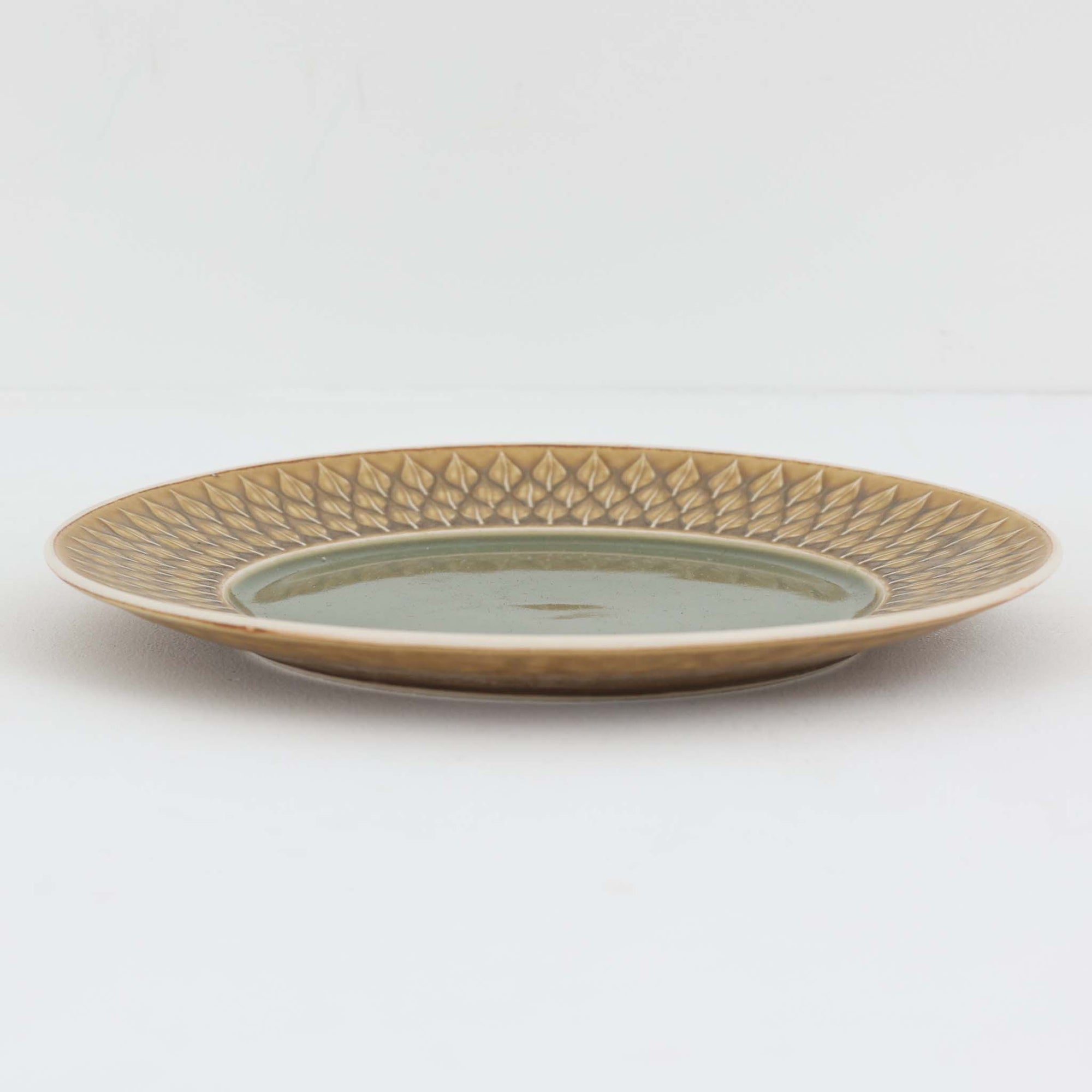 デンマークを代表するデザイナー、イェンス・H・クイストゴーによる「Relief（レリーフ）」シリーズのプレートです。一面に施されたレリーフ装飾が、自然の息吹を感じさせます。デンマークではスウェーデンやフィンランドの陶器メーカーと並んで今でも非常に人気のある商品となります。
