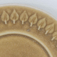 デンマークを代表するデザイナー、イェンス・H・クイストゴーによる「Relief（レリーフ）」シリーズのヴィンテージカップ&ソーサーです。マットなベージュ釉薬に丹念に浮かび上がる葉や木々の〈レリーフ〉装飾が印象的です。素朴で温もりある厚みのあるフォルムは、北欧の静かな森の風景を感じさせます。デンマークではスウェーデンやフィンランドの陶器メーカーと並んで今でも非常に人気のある商品となります。