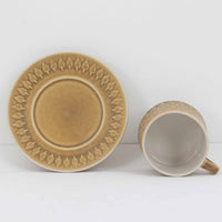 デンマークを代表するデザイナー、イェンス・H・クイストゴーによる「Relief（レリーフ）」シリーズのヴィンテージカップ&ソーサーです。マットなベージュ釉薬に丹念に浮かび上がる葉や木々の〈レリーフ〉装飾が印象的です。素朴で温もりある厚みのあるフォルムは、北欧の静かな森の風景を感じさせます。デンマークではスウェーデンやフィンランドの陶器メーカーと並んで今でも非常に人気のある商品となります。